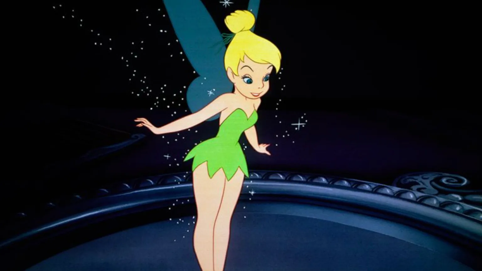 Tinker Bell, the fairy from Peter Pan, glowing with sparkles against a dark background in an animated scene.