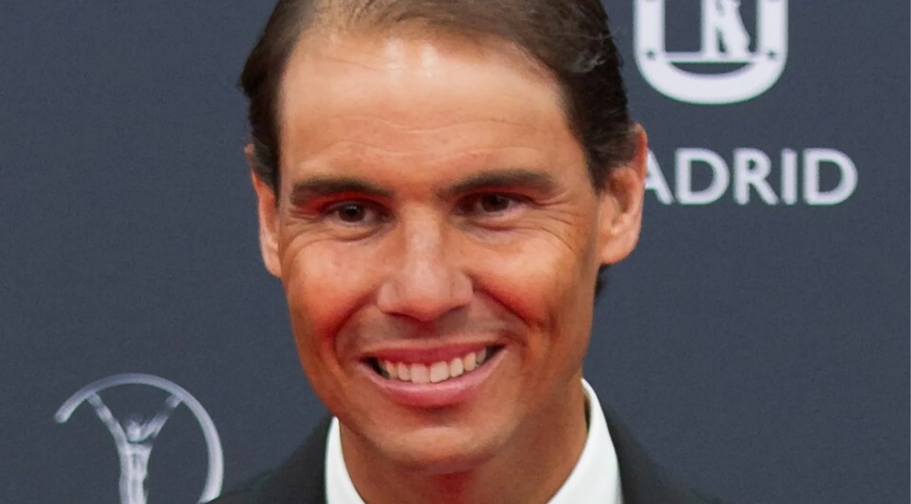 Athlete smiling at an event with Madrid backdrop, related to the sport quiz on can you outsmart this pub quiz.