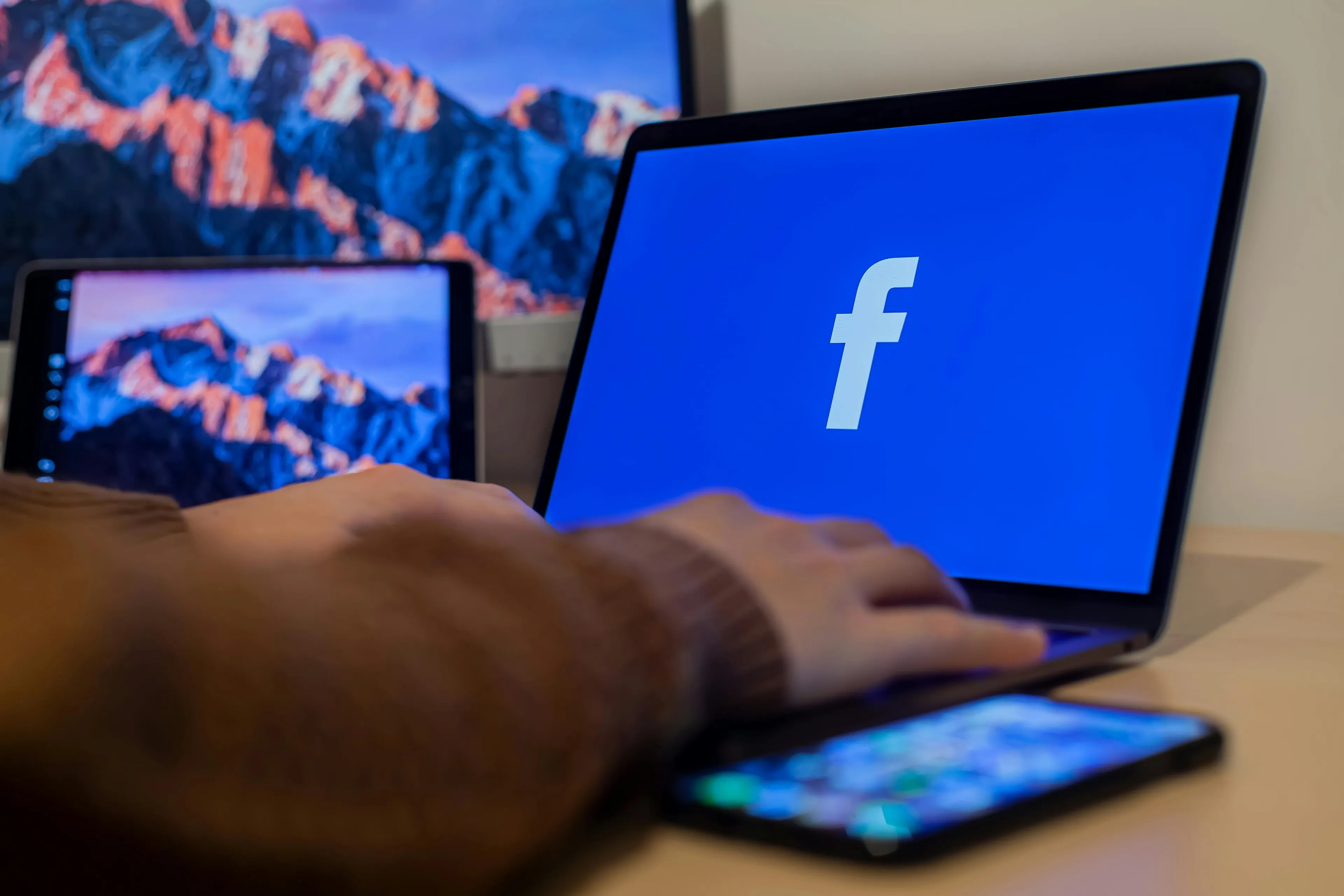 Person using a laptop displaying the Facebook logo, related to the pub quiz question about the year Facebook launched.