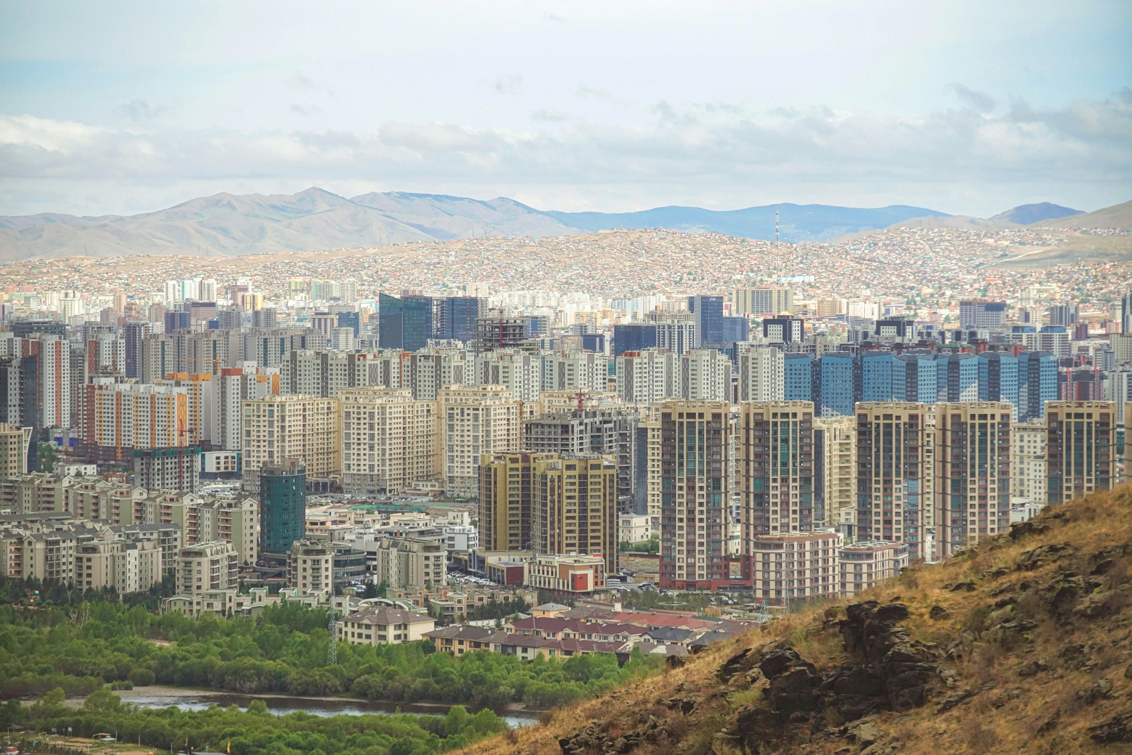 View of Ulaanbaatar city buildings and mountains, a visual hint for the geography challenge guessing the country capital.