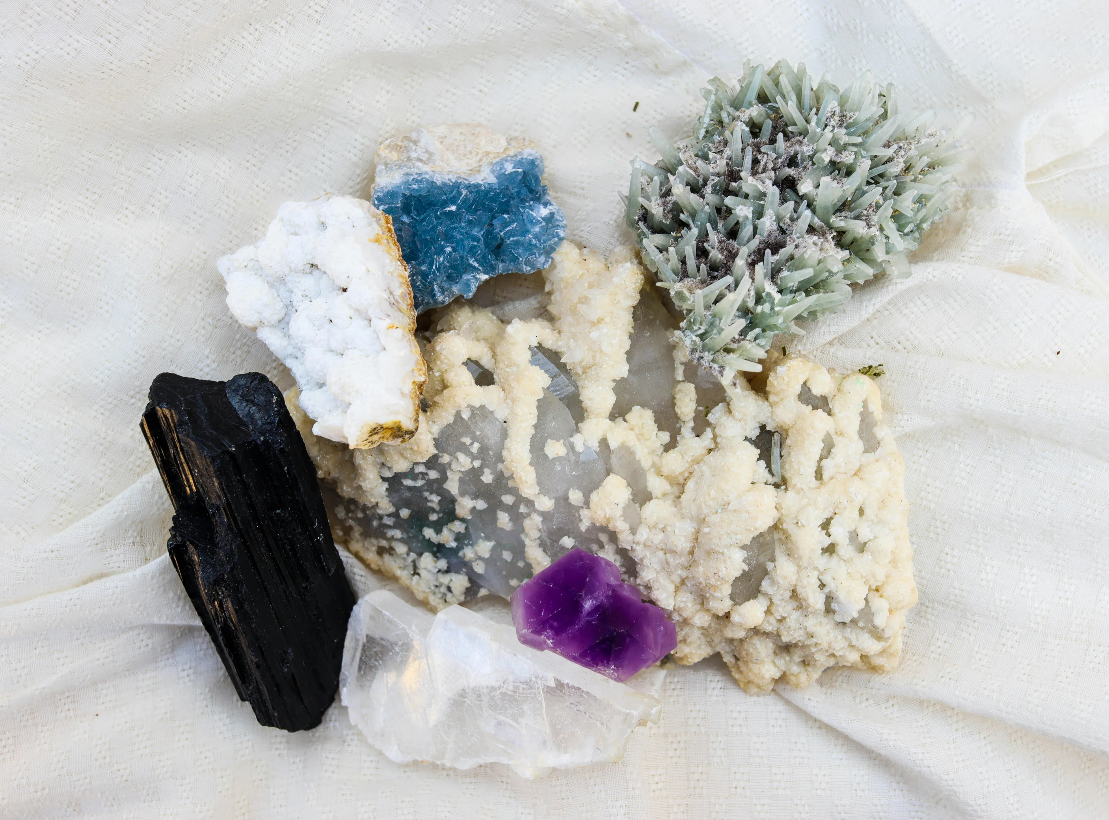 Various colorful mineral specimens displayed on a textured fabric background highlighting hardest natural substance concept