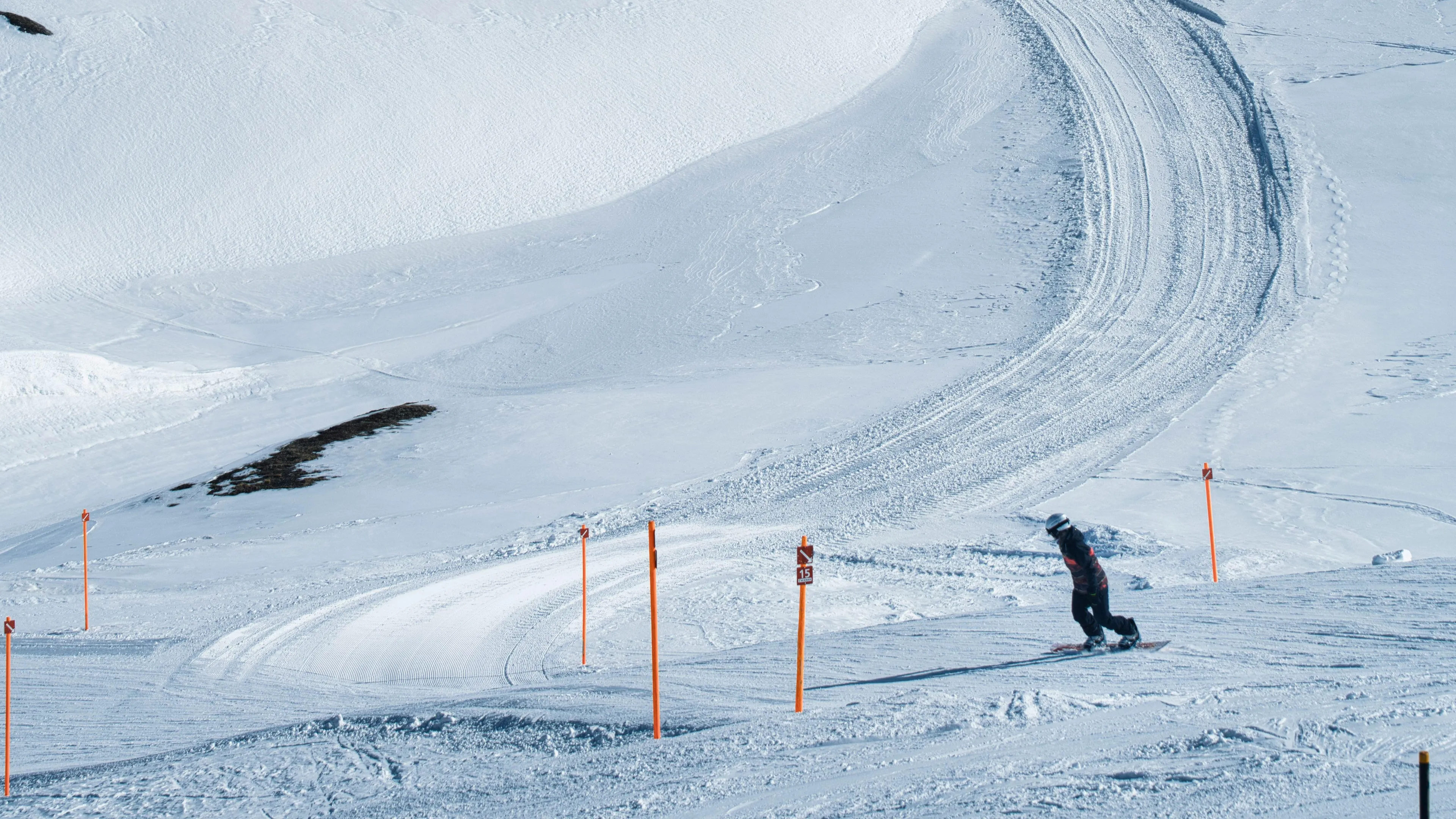 Snowboarder moving down a snowy slope illustrating friction as resistance between surfaces in motion.