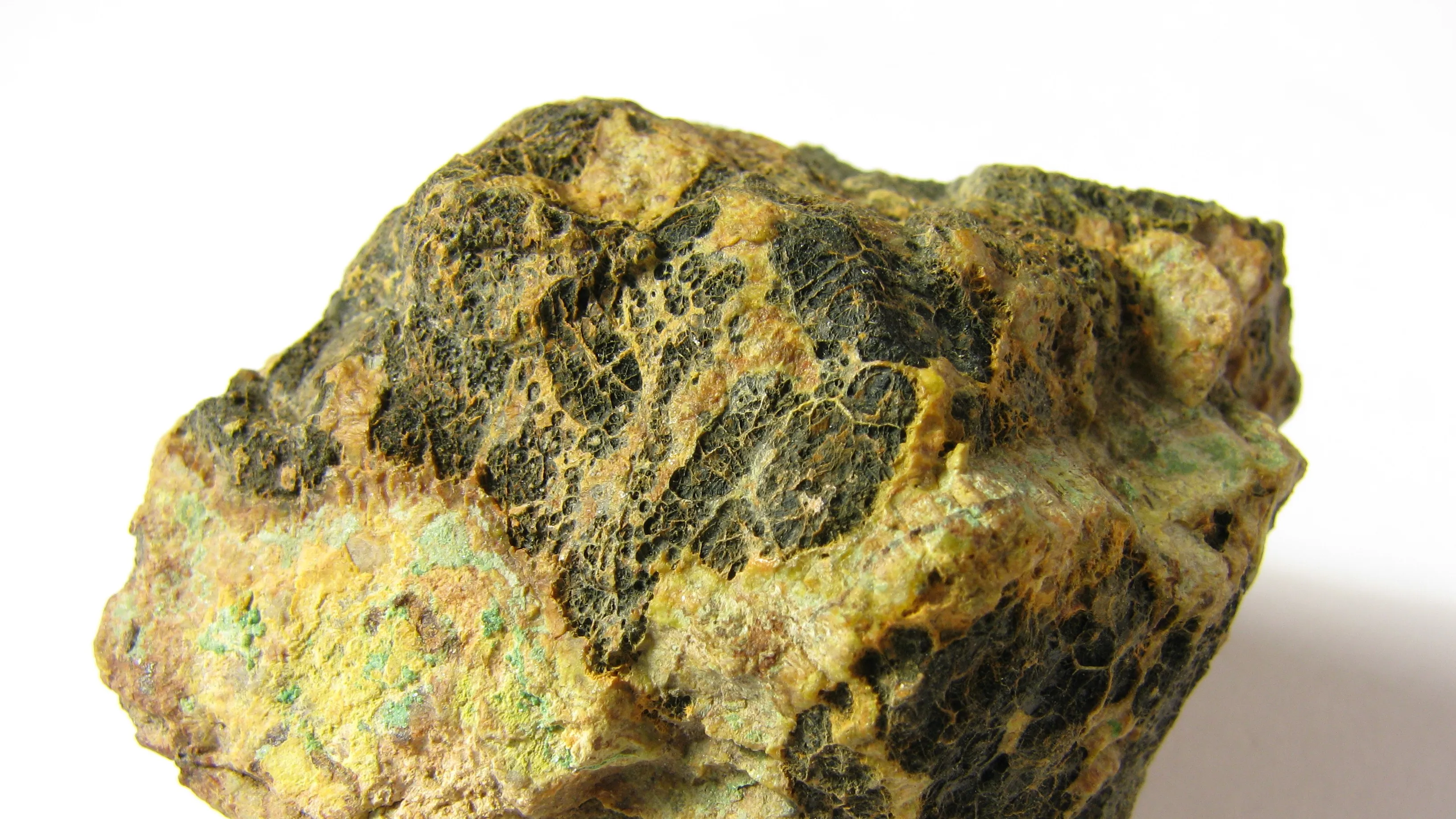 Rough sample of the heaviest naturally occurring element uranium with yellow and dark textured surface close-up.