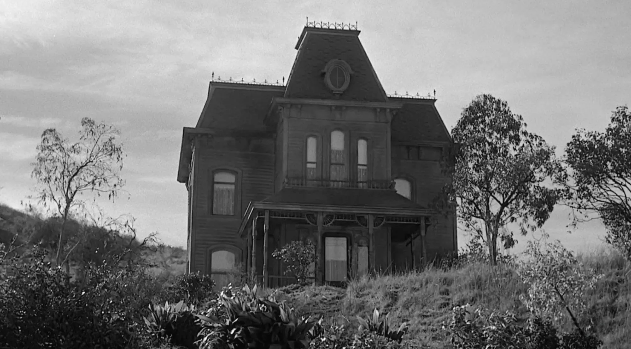 Black and white scene of a spooky Victorian house in a 60s movie scene to uncover which 1960s movie it is from