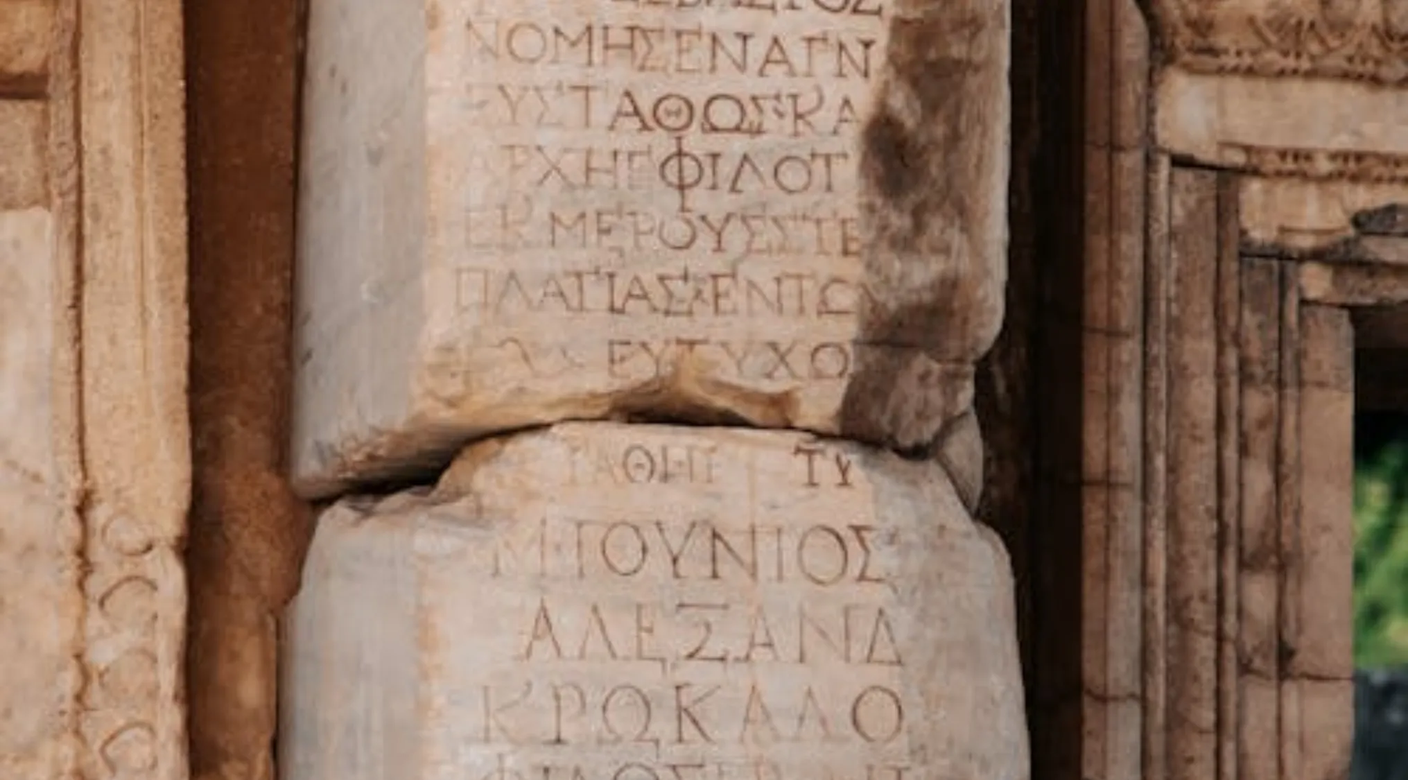 Ancient stone carved with Greek letters, highlighting words linked to Greek mythology and general knowledge questions.