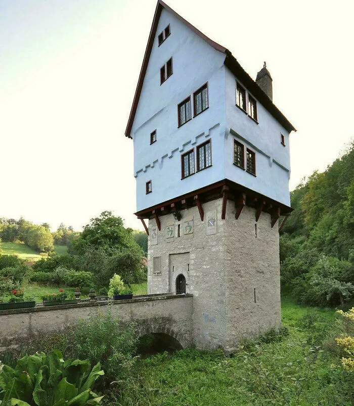 An unusual historic blue house built on top of a stone tower base, exemplary of historical finds.