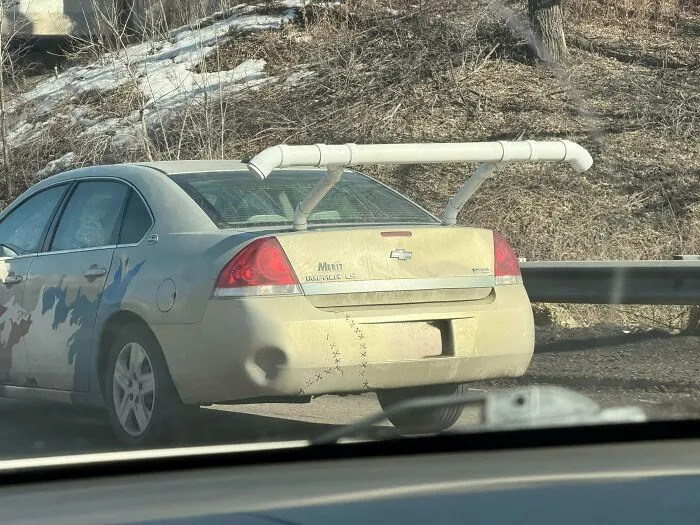A car featuring a homemade rear spoiler made out of white PVC pipes, representing funny DIY projects.