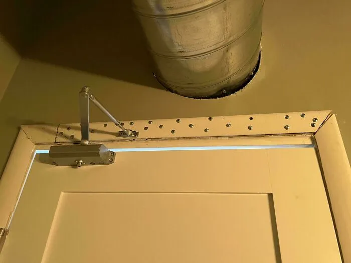 Top of door frame secured with dozens of random screws as a questionable DIY project.