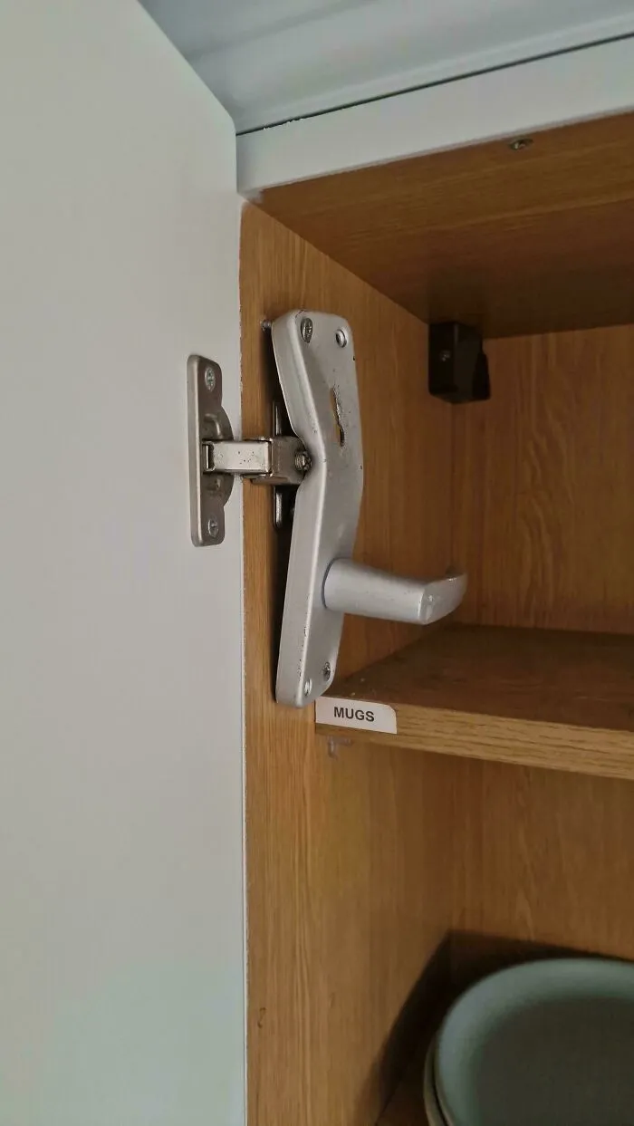 Door handle bizarrely attached to cabinet hinge as one of the questionable DIY projects.