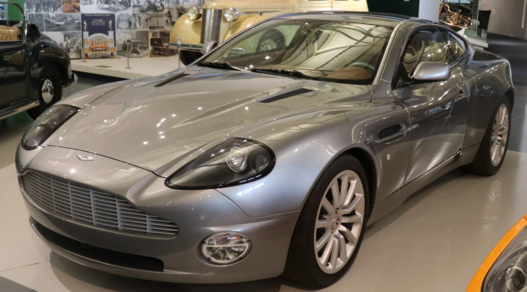 Silver Aston Martin used to promote a James Bond film displayed in a museum setting, guessing the price at auction 2024.