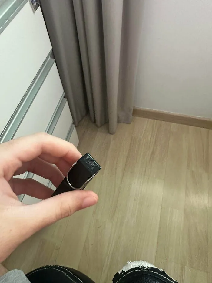 Hand holding a small vintage black IBM USB flash drive, an example of old products still working.
