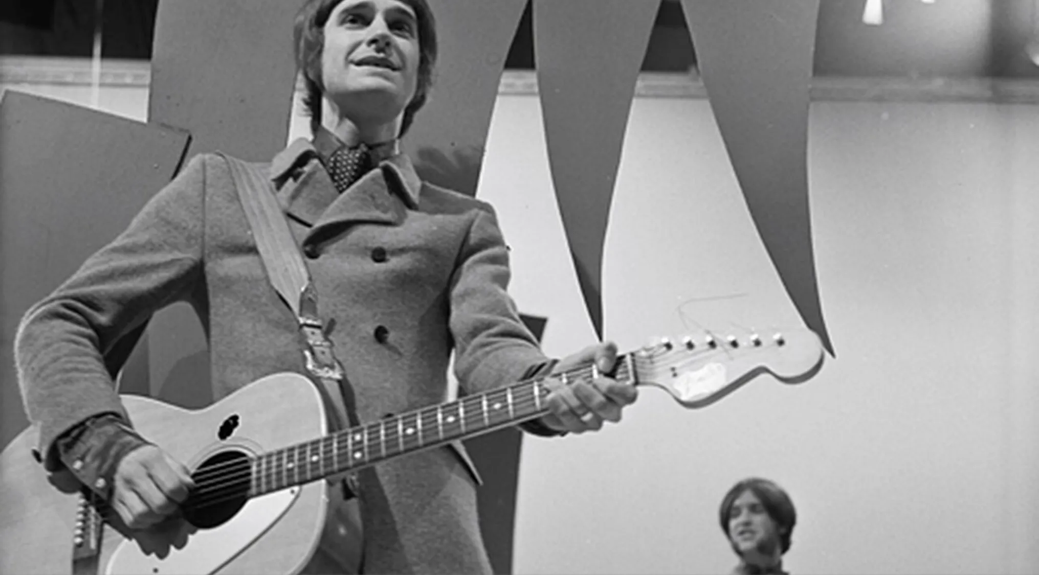Ray Davies playing guitar on stage with Dave Davies, related to songwriters of Satisfaction.