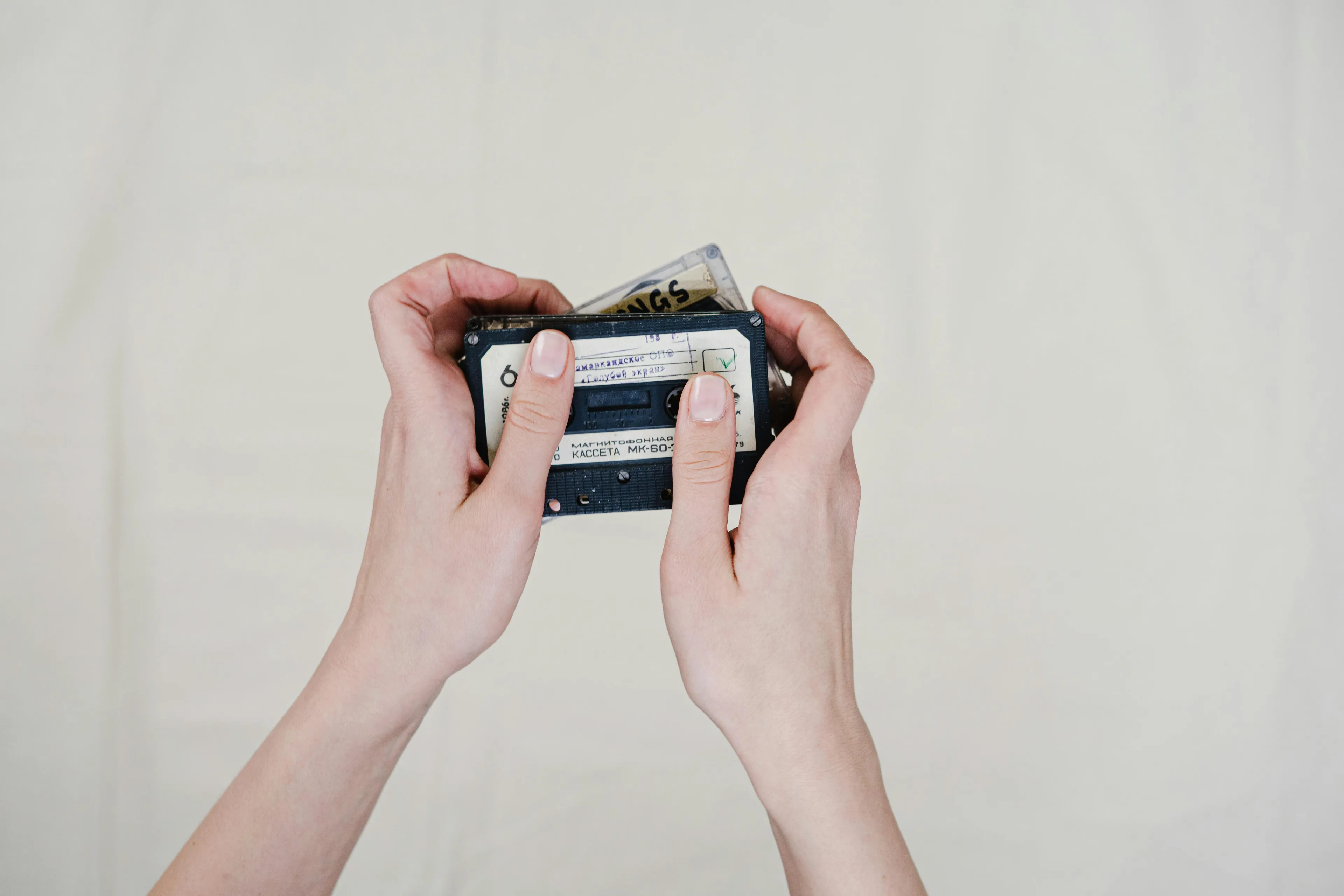 Hands holding a vintage cassette tape representing a personalized playlist as a favorite type of party favor.