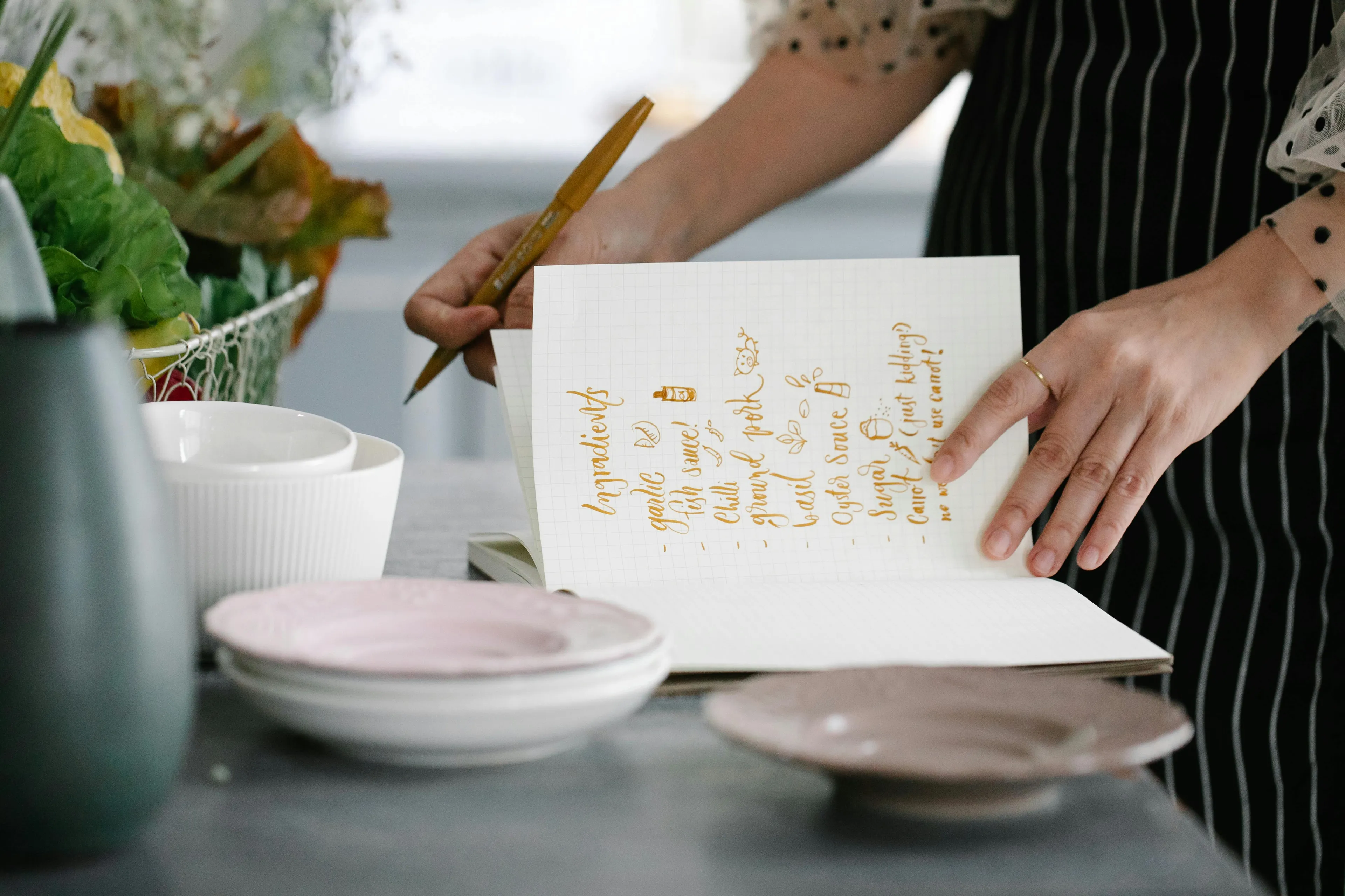 Handwritten recipe card held by a person in a kitchen setting, featuring a favorite type of party favor idea.