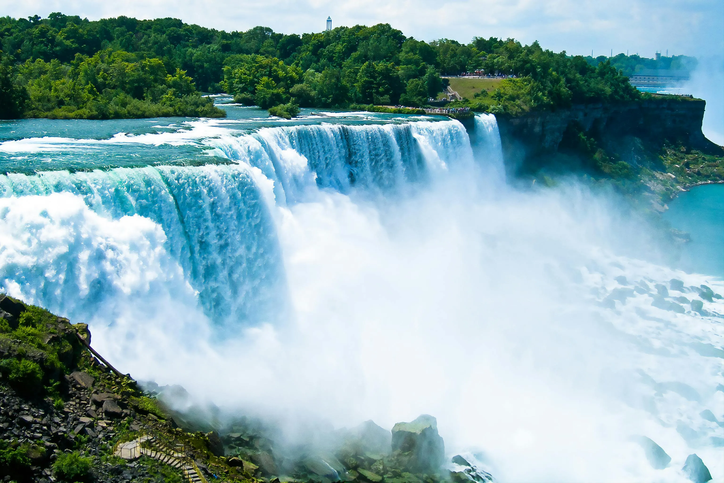 Niagara Falls waterfall cascading with mist and greenery in a natural scenic landmark setting.