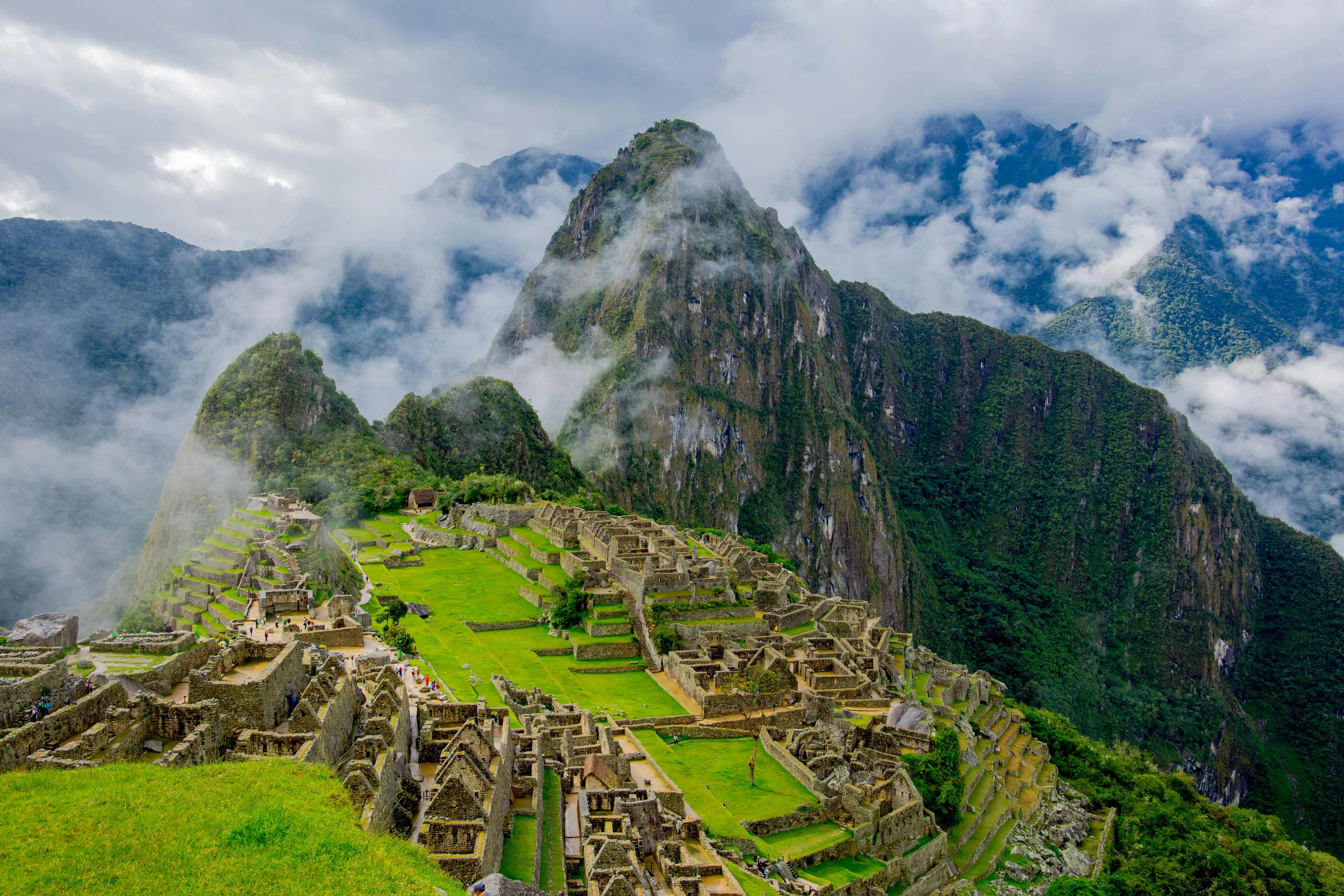 Machu Picchu ancient Incan city ruins set high in the Andes Mountains with mist and steep green peaks surrounding it