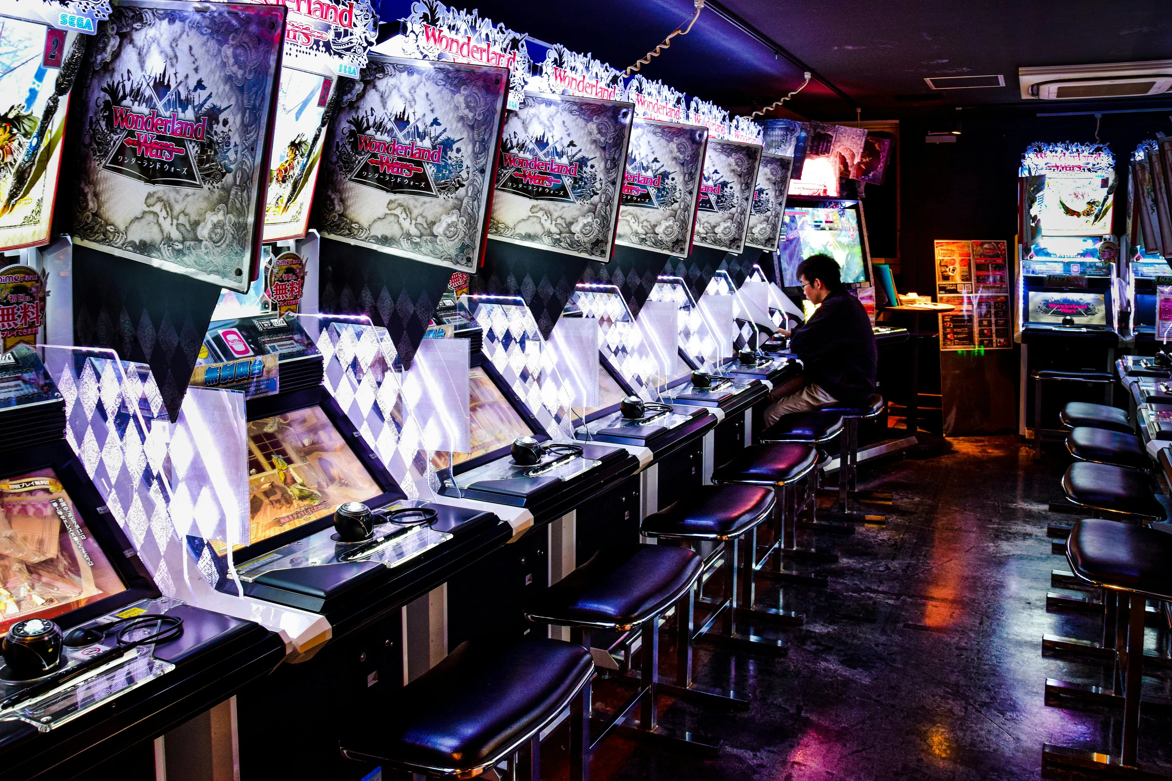 Retro arcade with rows of glowing vintage pinball machines and a person playing in a dimly lit neighborhood store setting.