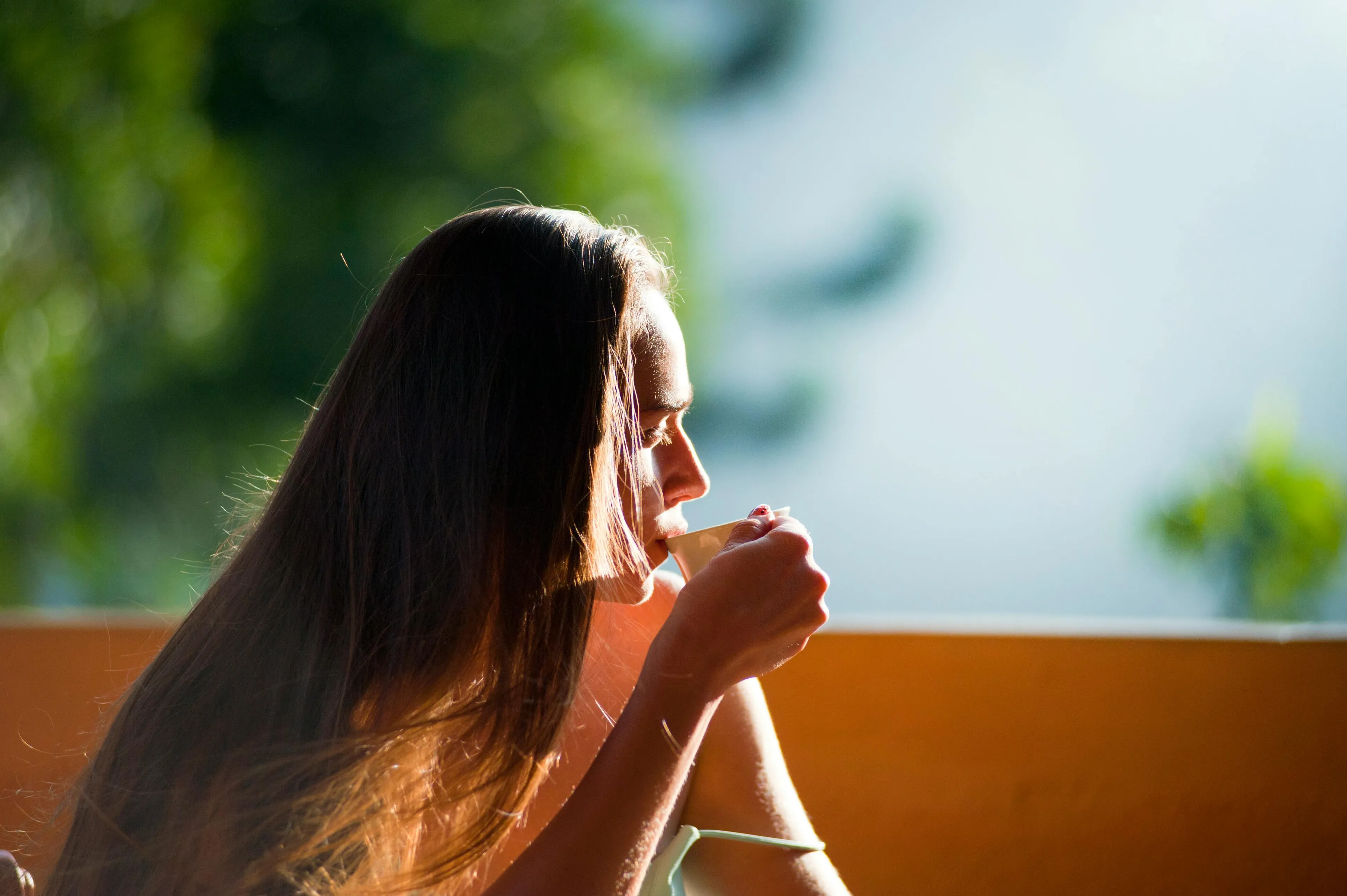 Woman enjoying a morning beverage outdoors, reflecting on where her life would be set to start the day.