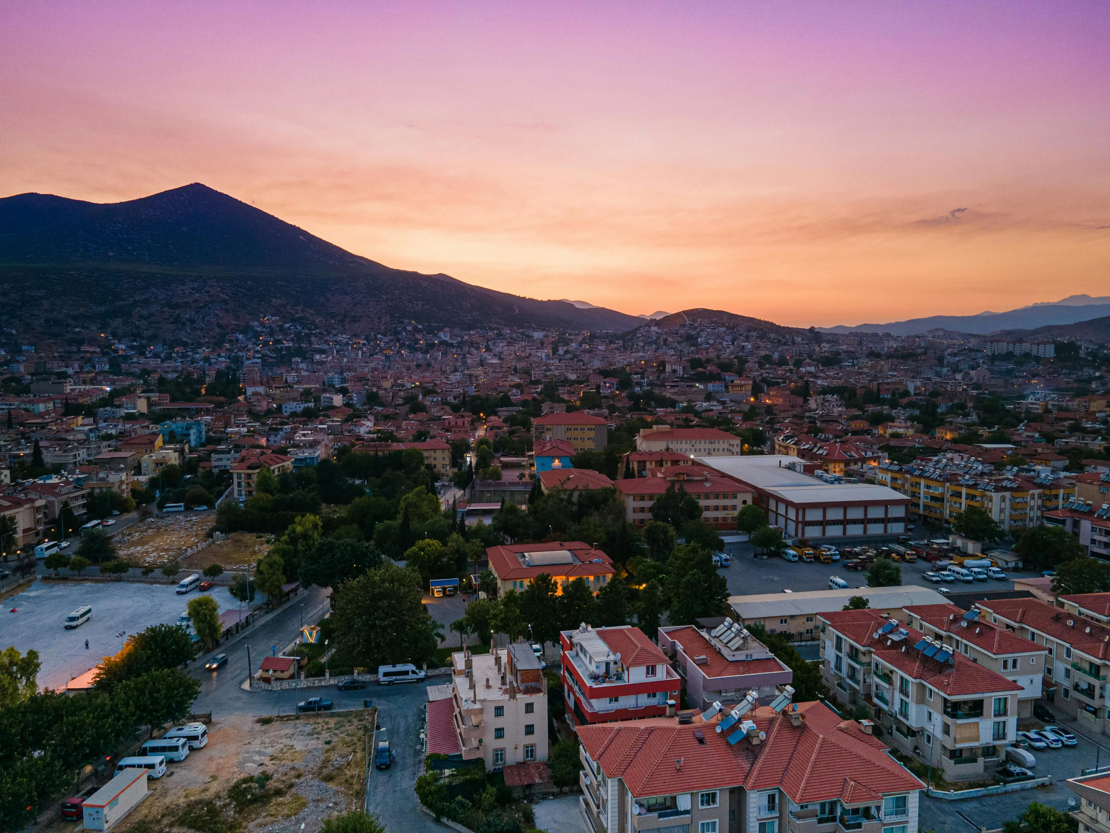 Aerial view of a hometown at sunset with houses and mountains, illustrating the relationship with your hometown.
