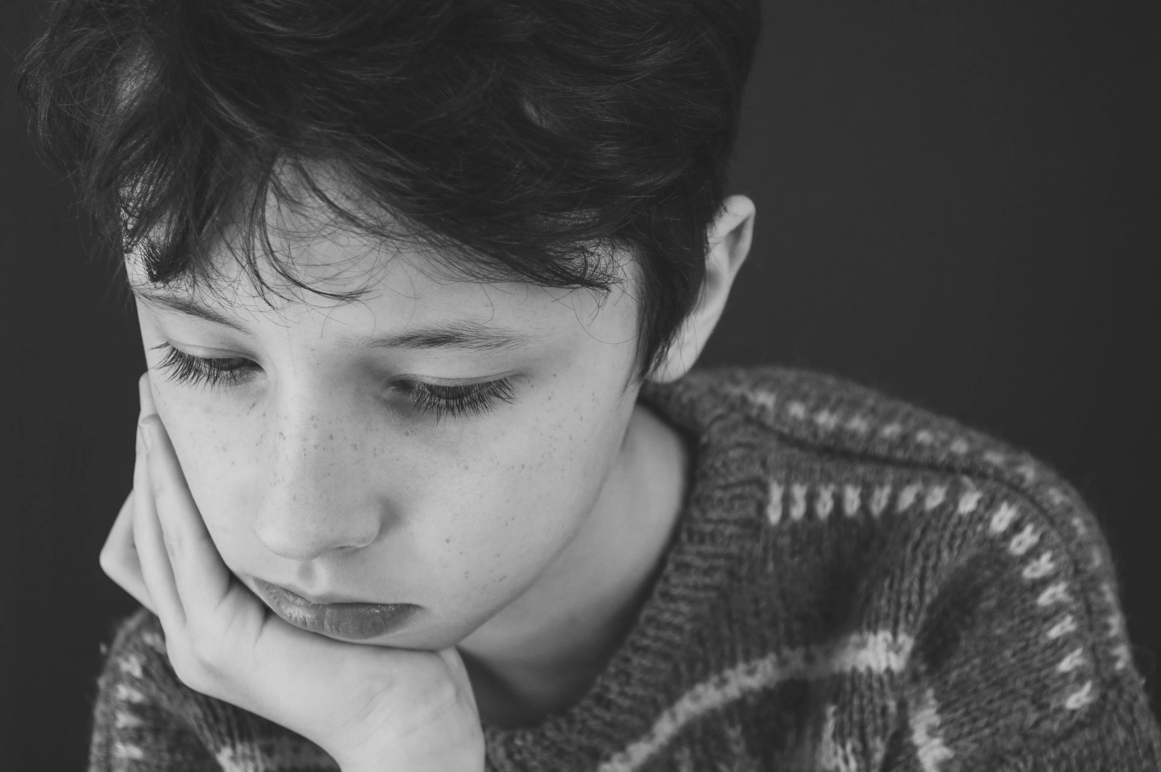 Sad boy with hand on face, reflecting on how to handle a bad day and where life would be set.