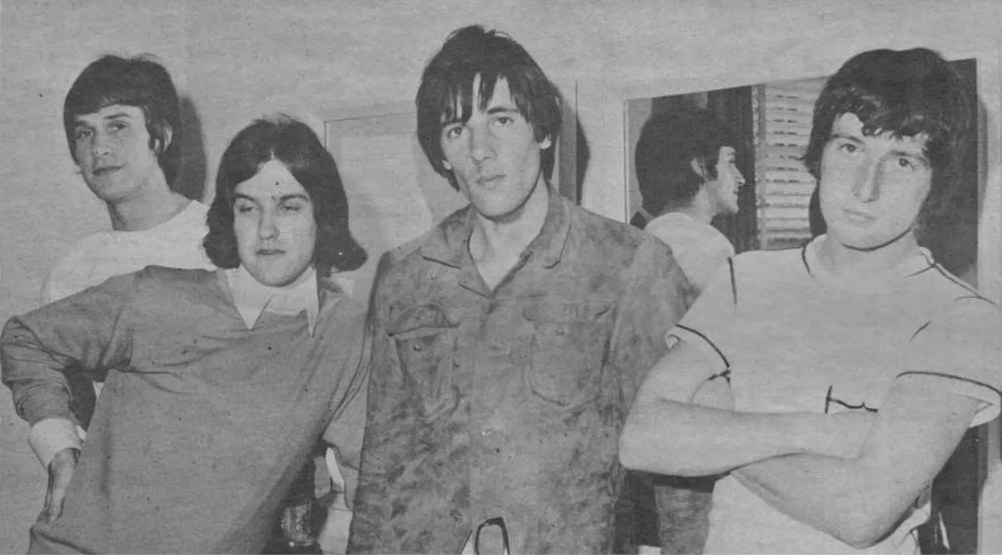 The Kinks band members posing in a black and white photo representing the British Invasion in the U.S. music scene.