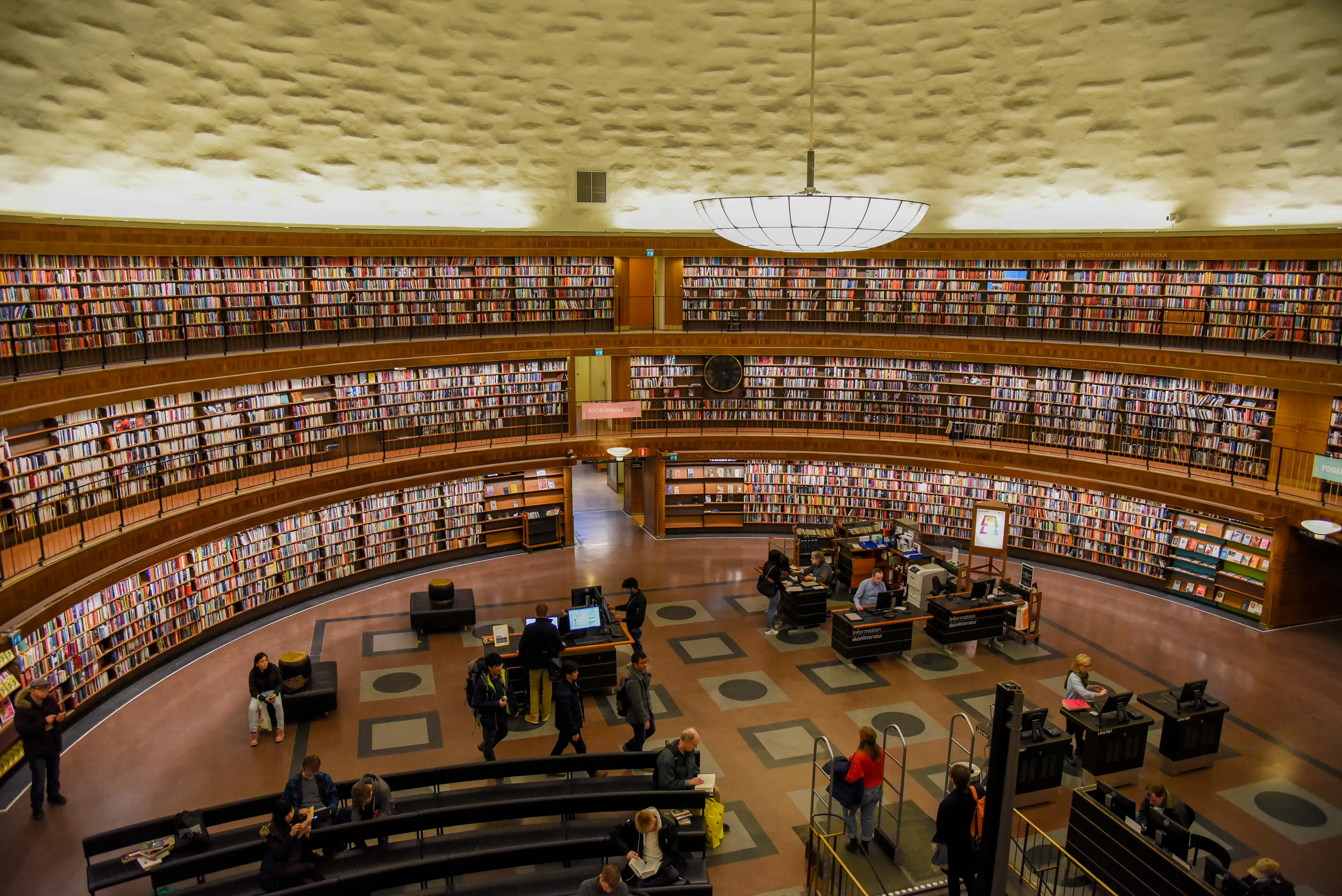 Spacious circular library section filled with bookshelves and visitors exploring where life could be set.