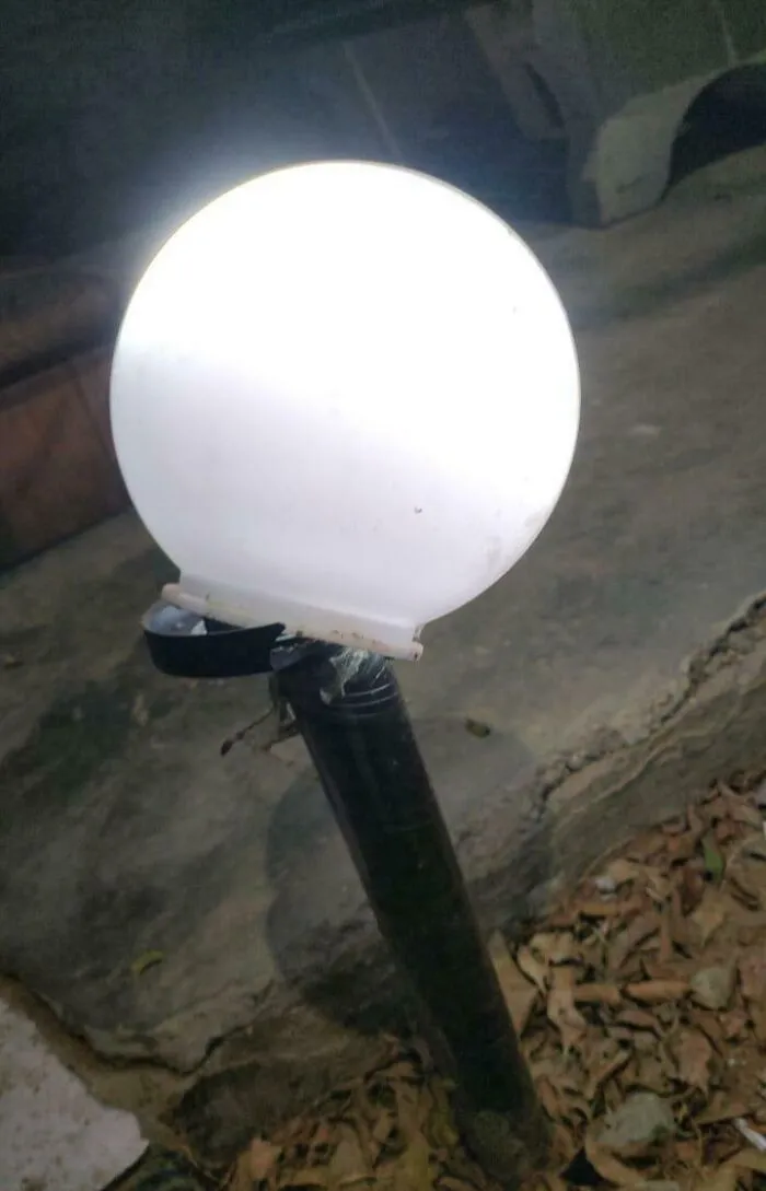 Broken outdoor lamp with a cracked white globe revealing the true colors of faulty friends and shaming moments online.