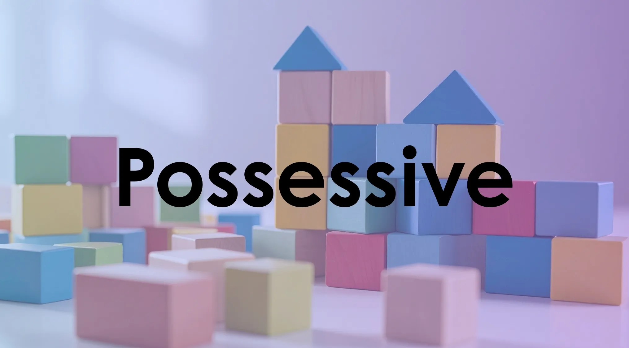 Colorful wooden blocks stacked with blue triangular tops on a white surface highlighting the word possessive form.