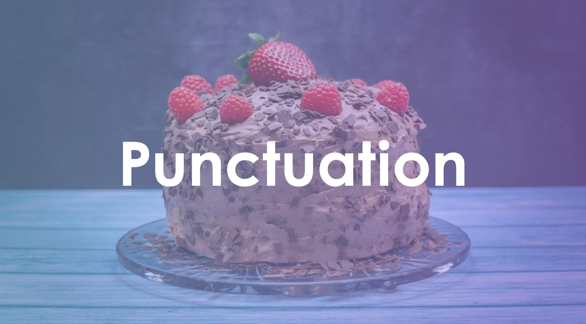 Chocolate cake topped with raspberries and a strawberry, with the word punctuation in bold letters over the image.