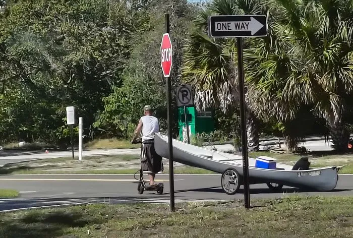 Love My State. This Man Has Put A Canoe On Wheels, Strapped The Canoe To His Waist, And Is Off To A Fun Day On The Water Via Electric Scooter