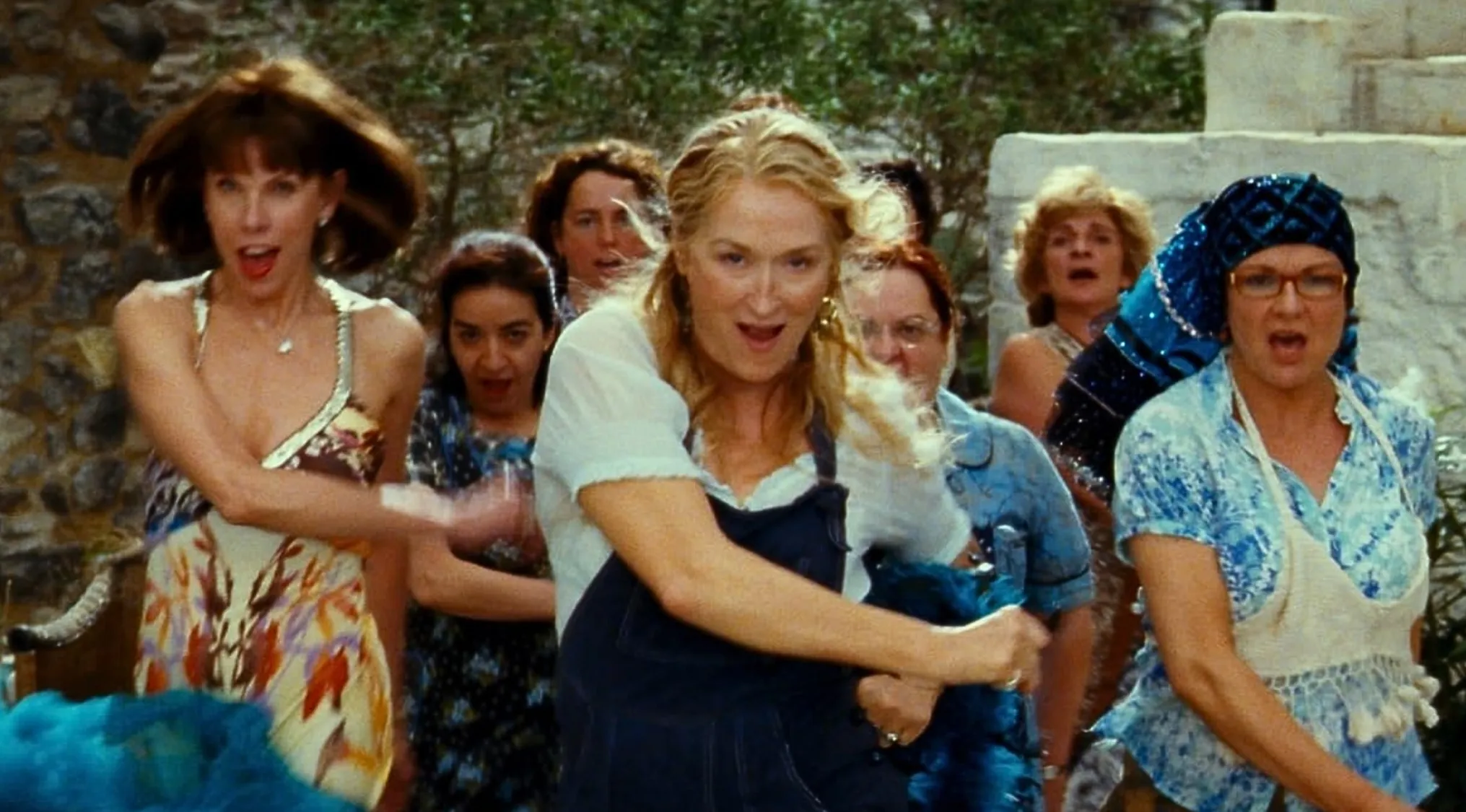 Scene from the musical film Mamma Mia featuring women dancing, with songs written by the band ABBA.