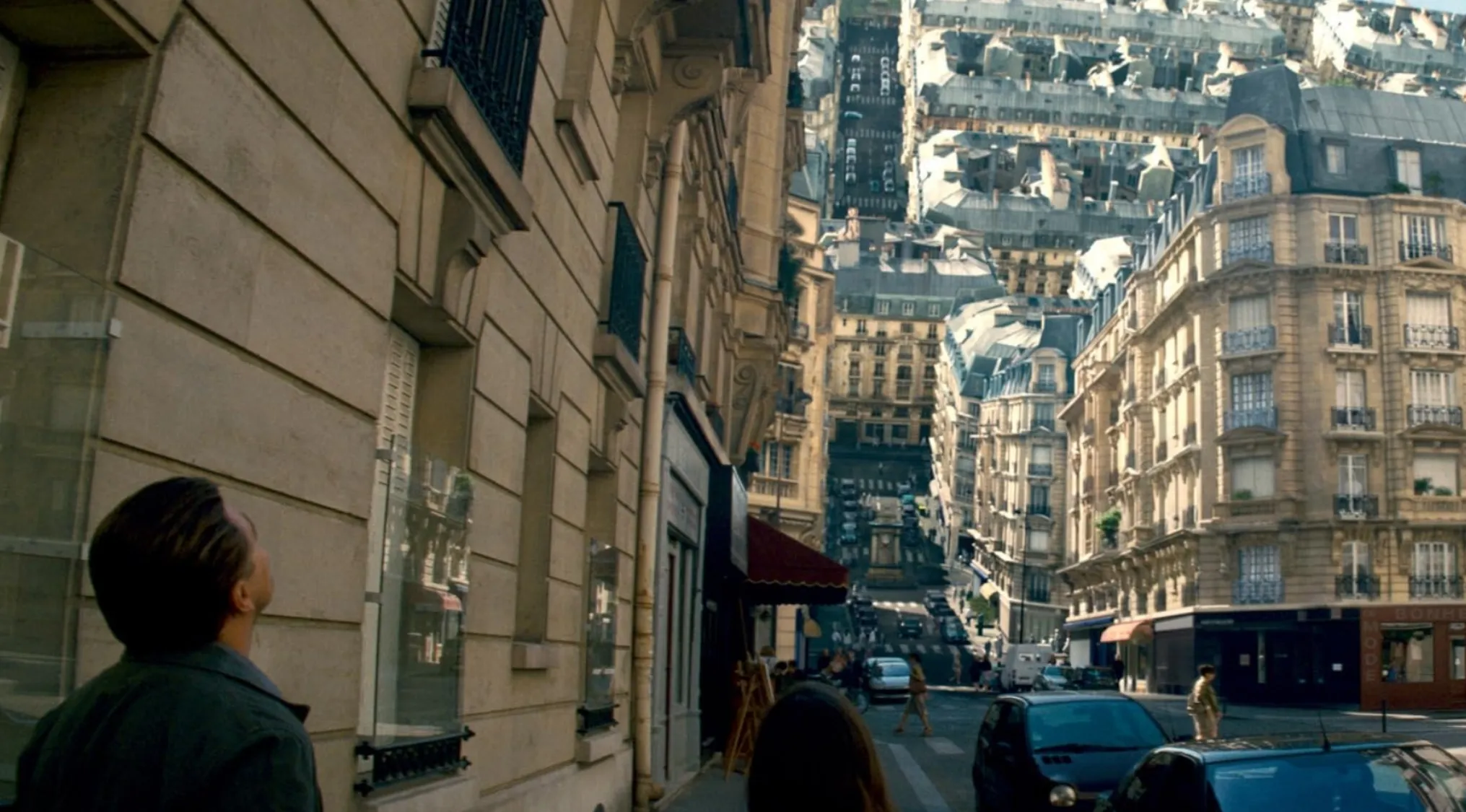 Scene from mind-bending 2010s movie showing a city street folding upward representing dream travel concept.