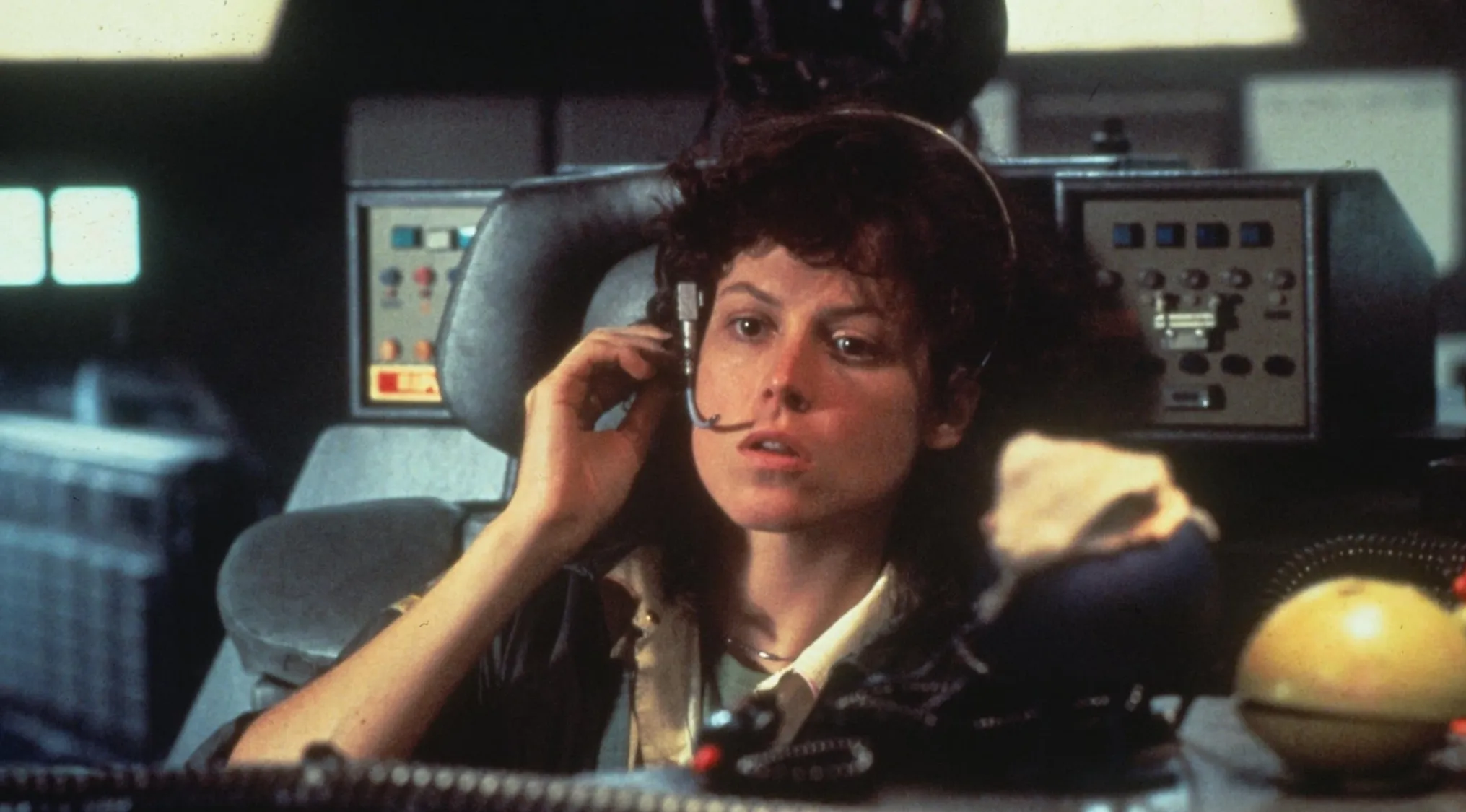 Woman wearing headset and sitting in spaceship cockpit in a successful 70s film scene from a movie quiz.
