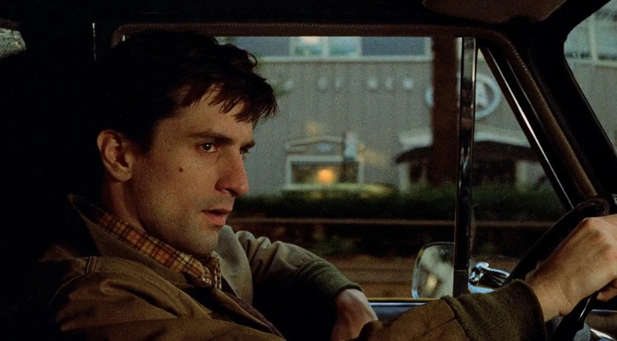 Close-up of a character driving in a car, featured in a 70s film in a movie quiz about 70s movies.