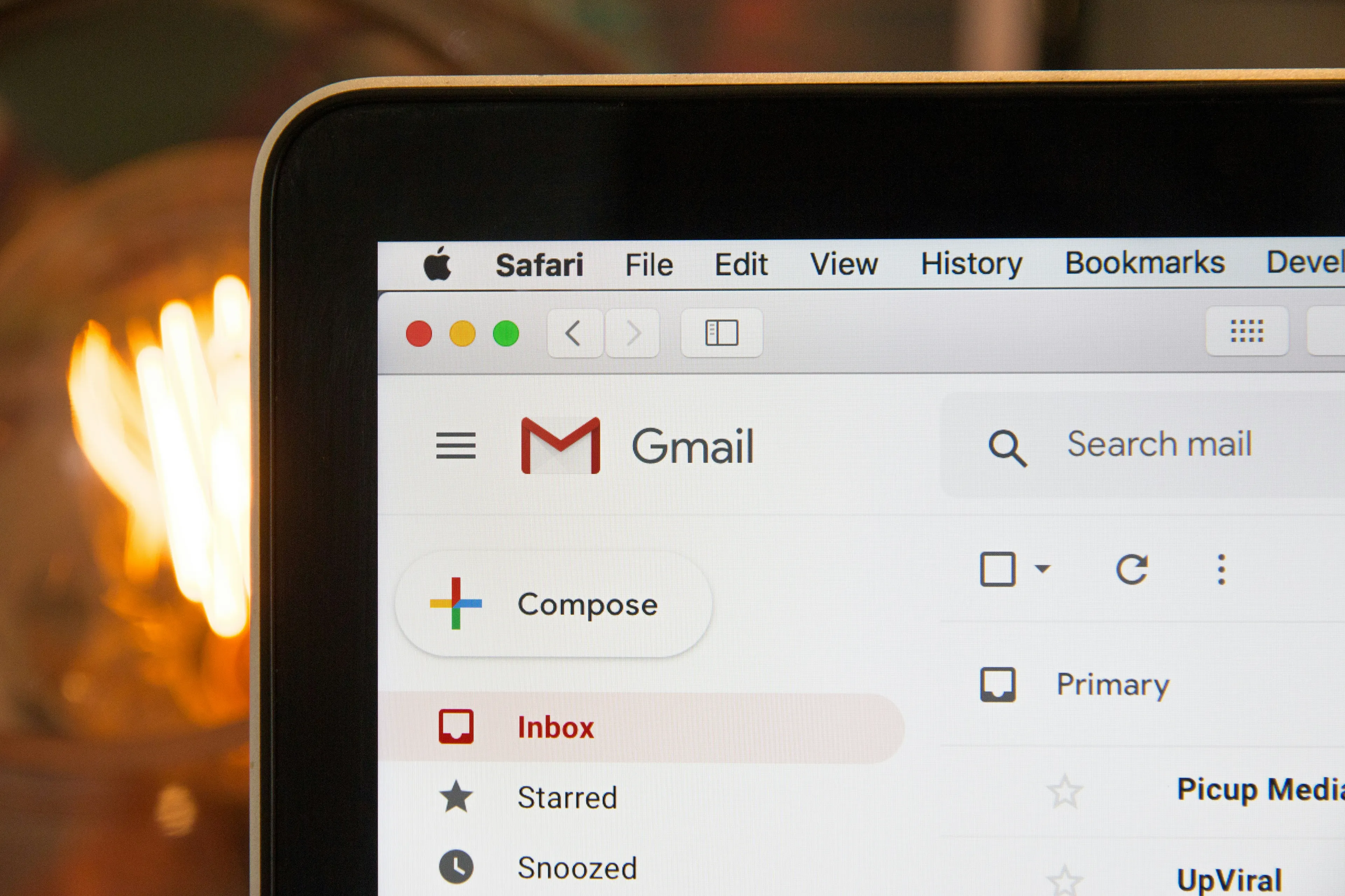 Gmail inbox open on a laptop screen showing email categories and search mail bar in Safari browser.