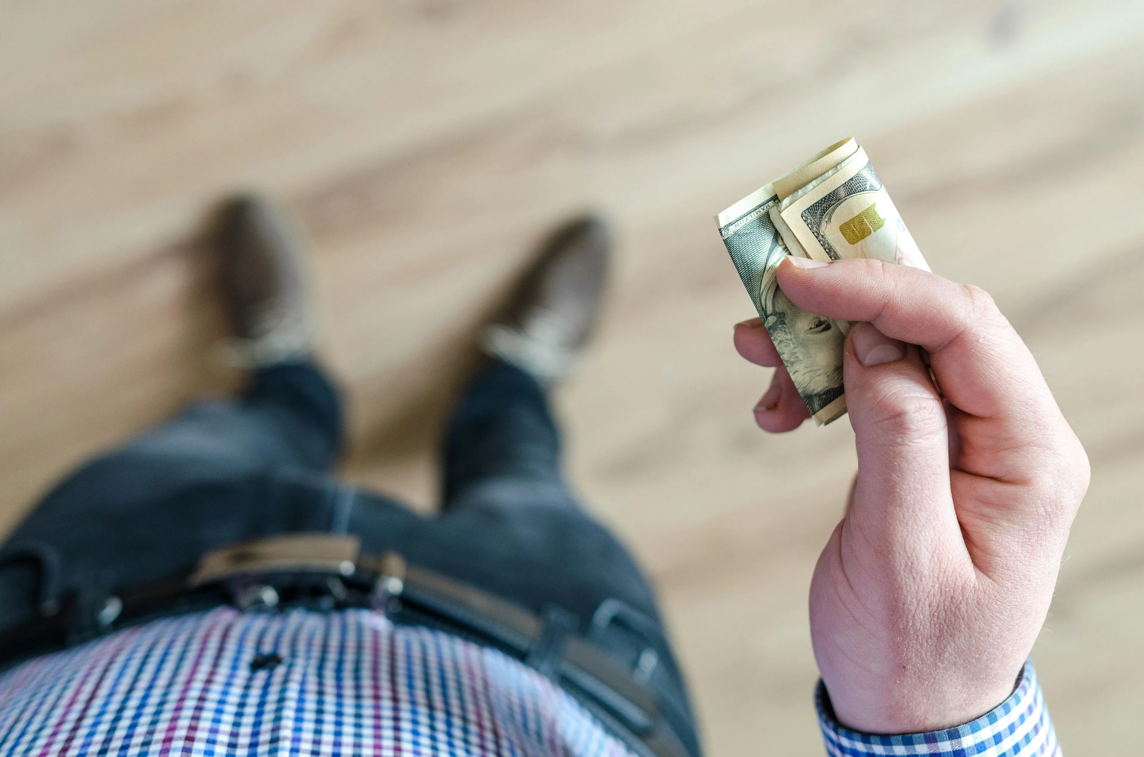 Person holding twenty dollars found on the sidewalk, reflecting on choices that align with what job matches your soul.