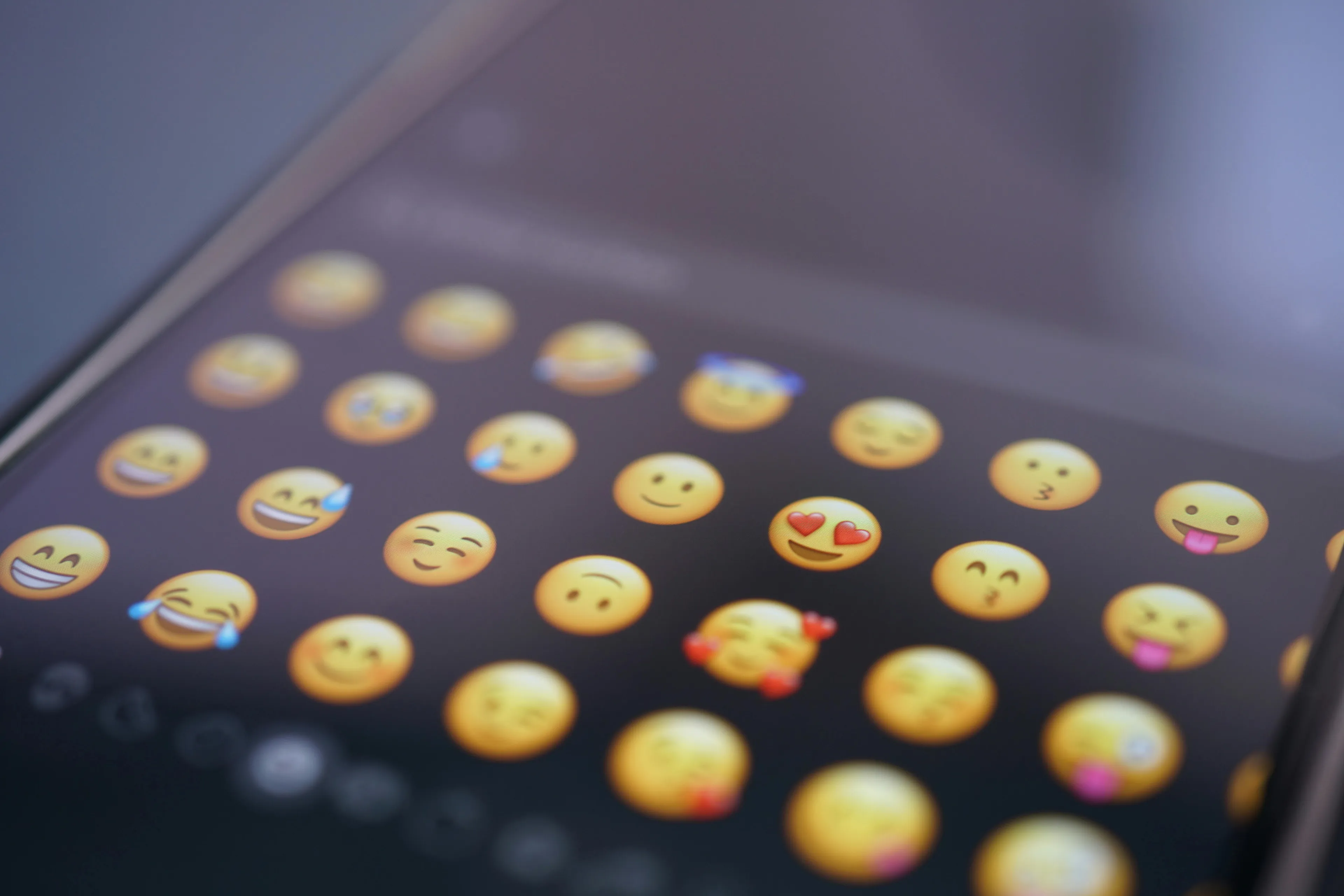 Close-up of a smartphone screen displaying various emojis to reply in a job-related text conversation about quitting.