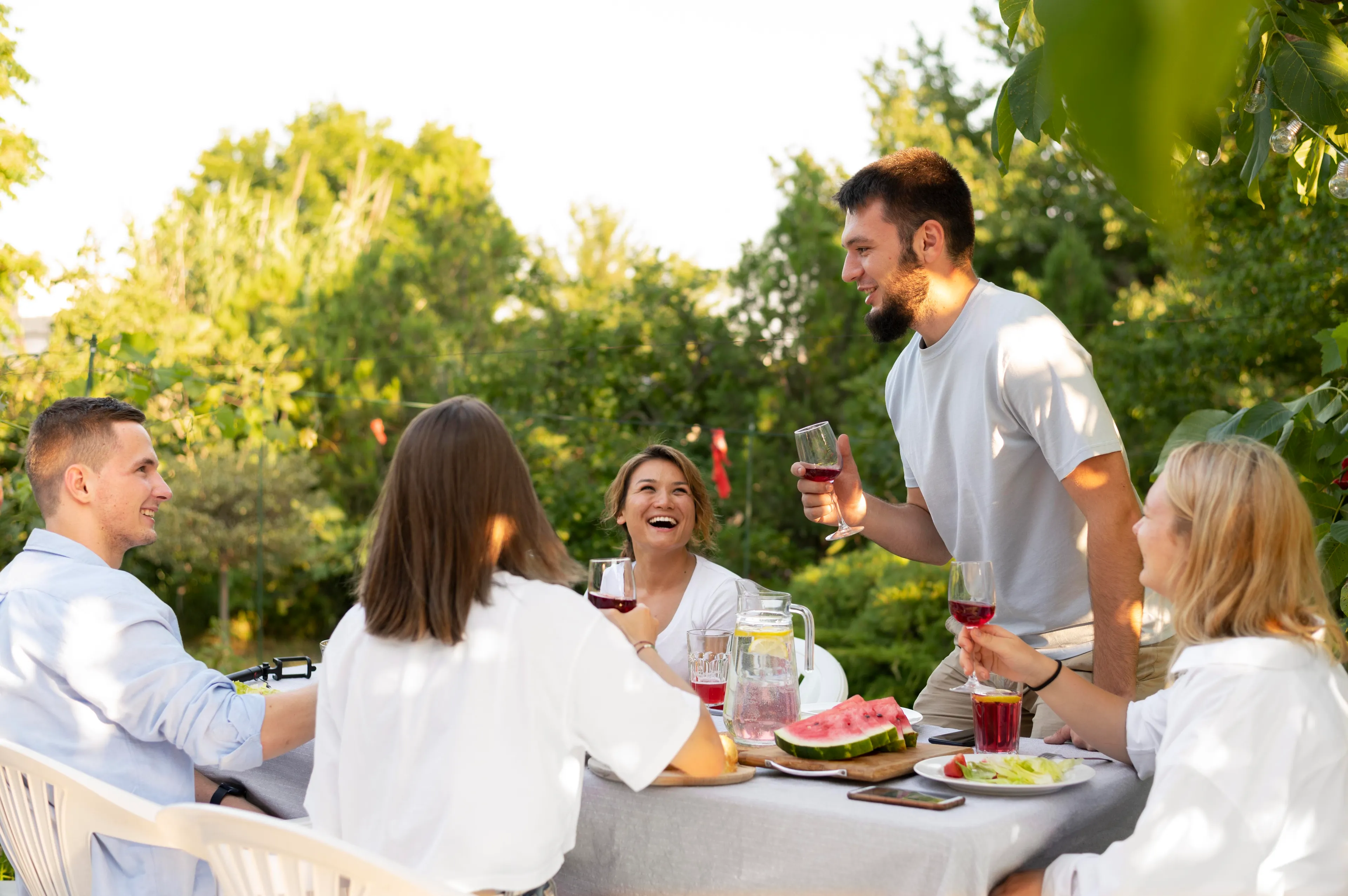 Group of friends at an outdoor reunion enjoying drinks and laughter, exploring what job matches your soul in a casual setting