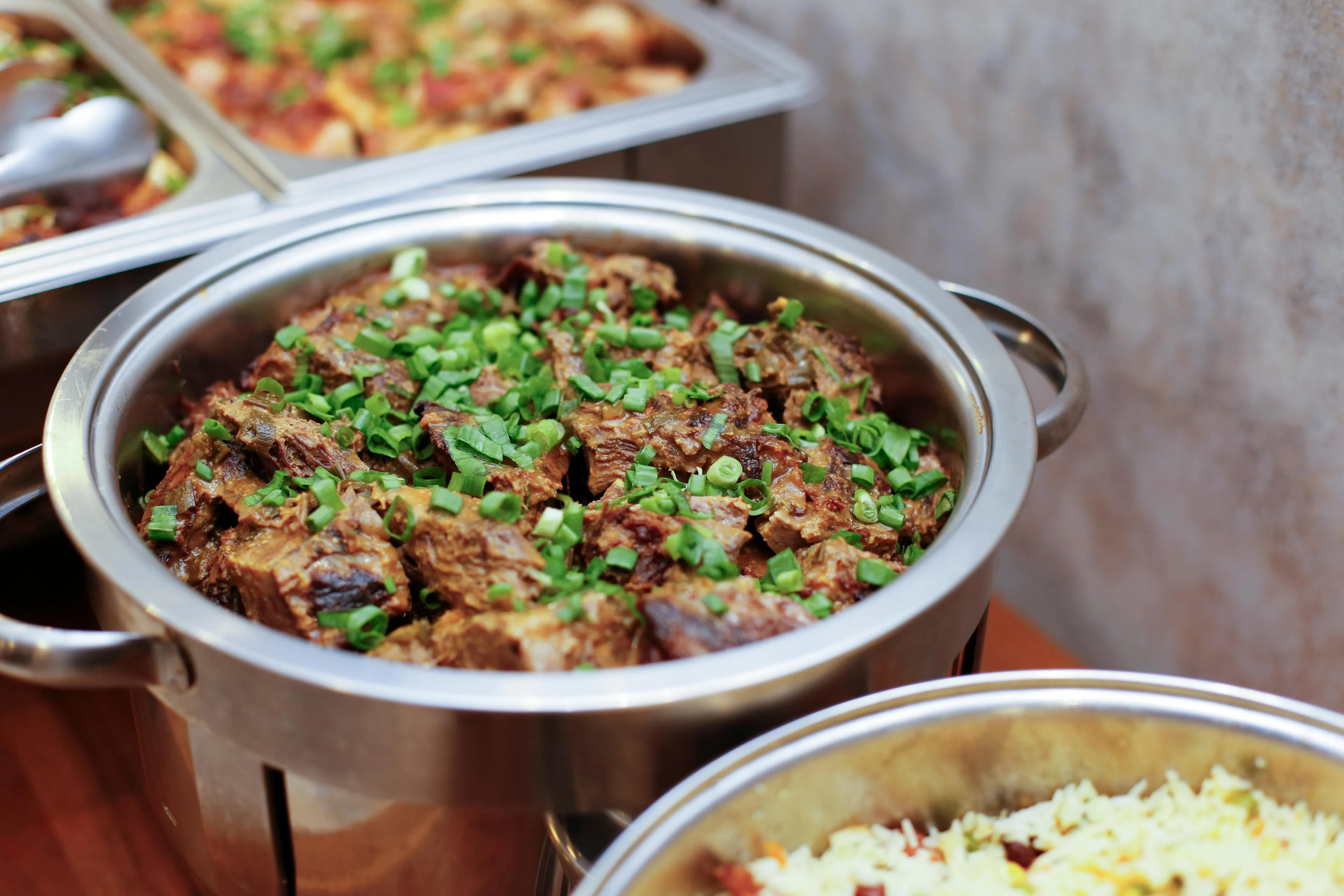 Serving delicious food at a hosting a potluck event with seasoned meat garnished with fresh green herbs
