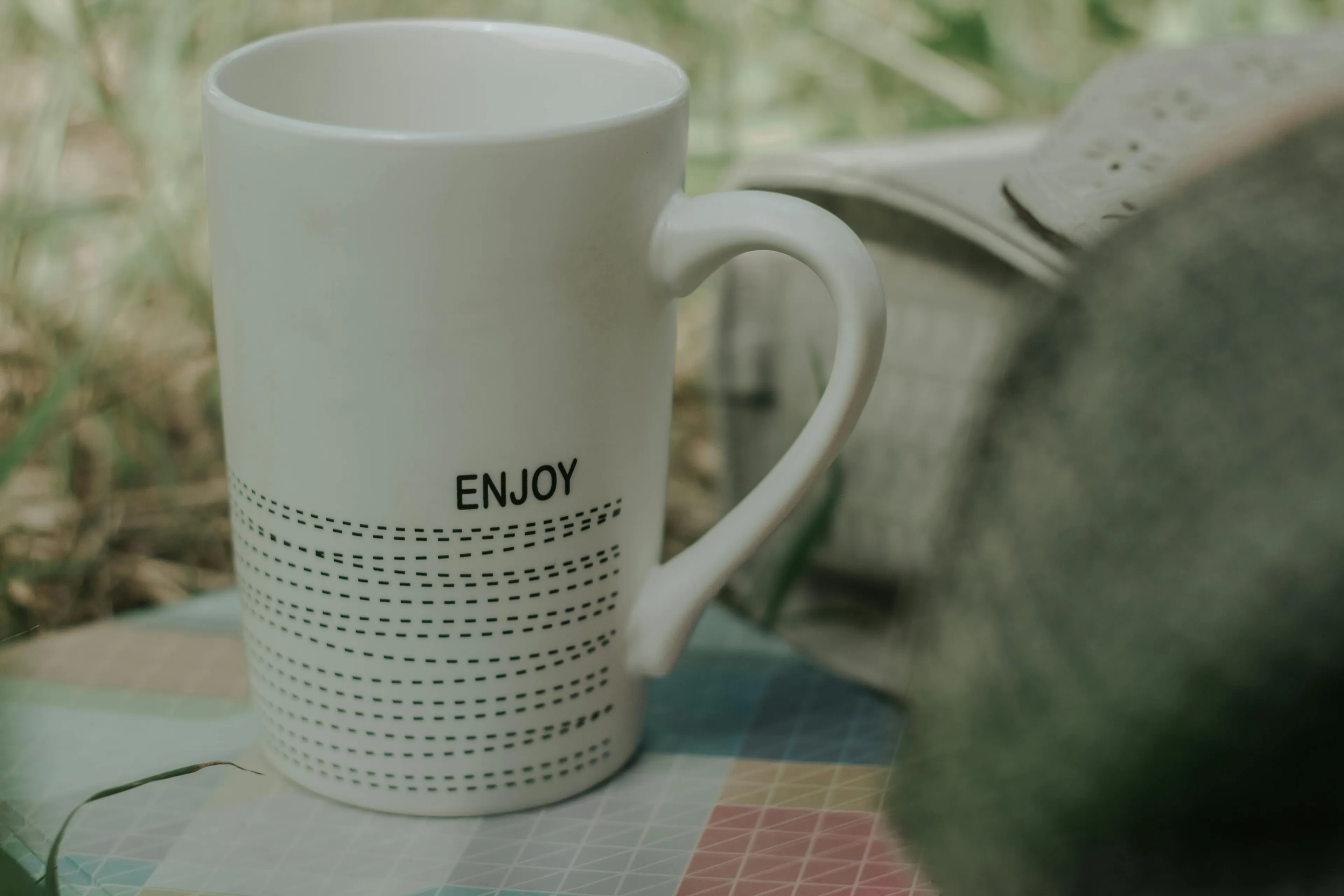 A minimal design coffee mug with the word enjoy, featuring clean lines and a simple, elegant style.