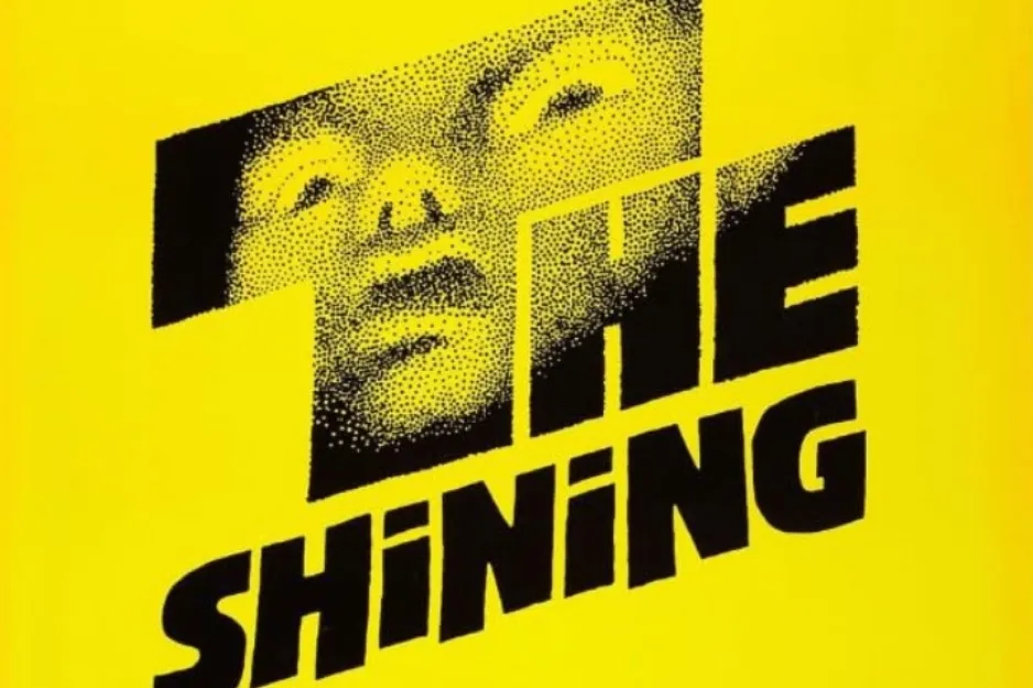 The Shining movie poster with stylized black text and a face emerging from the letter T on a bright yellow background.