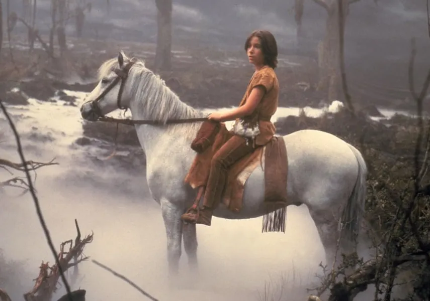 Young boy riding a white horse through a misty, enchanted forest scene from The NeverEnding Story movie.