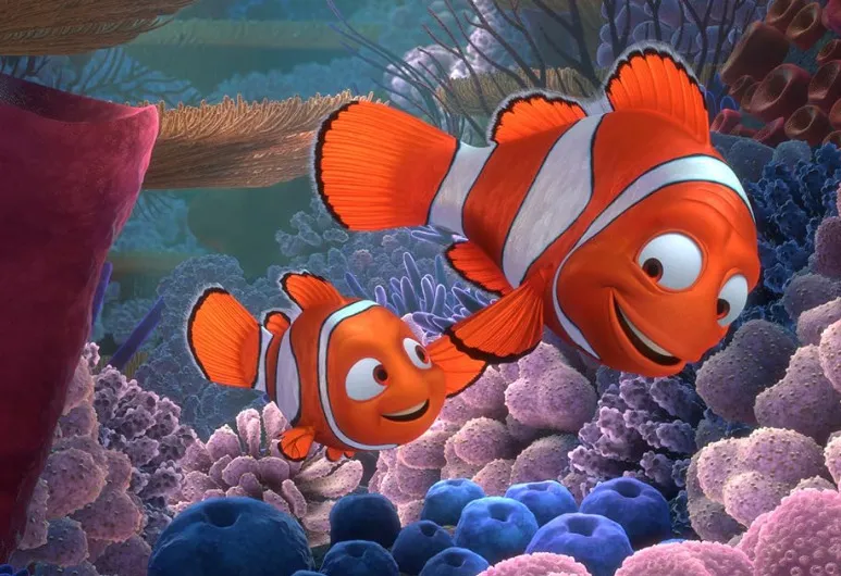 Two clownfish characters from Finding Nemo swimming happily among colorful coral reefs underwater.