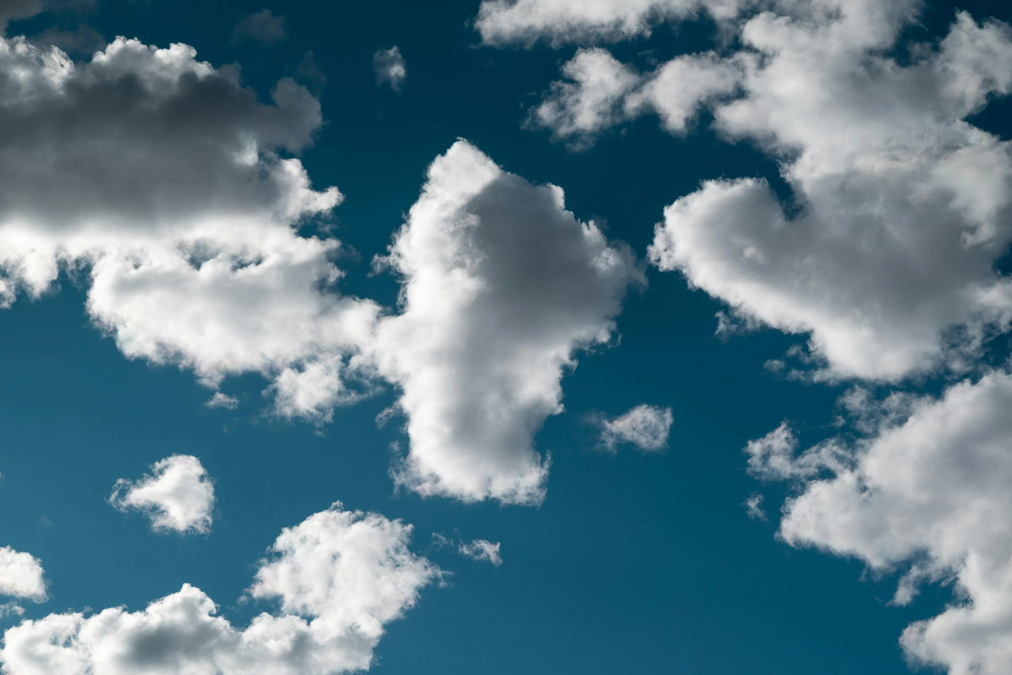Cloud shapes drifting across a clear blue sky during a favorite weather phenomenon to watch on a sunny day.