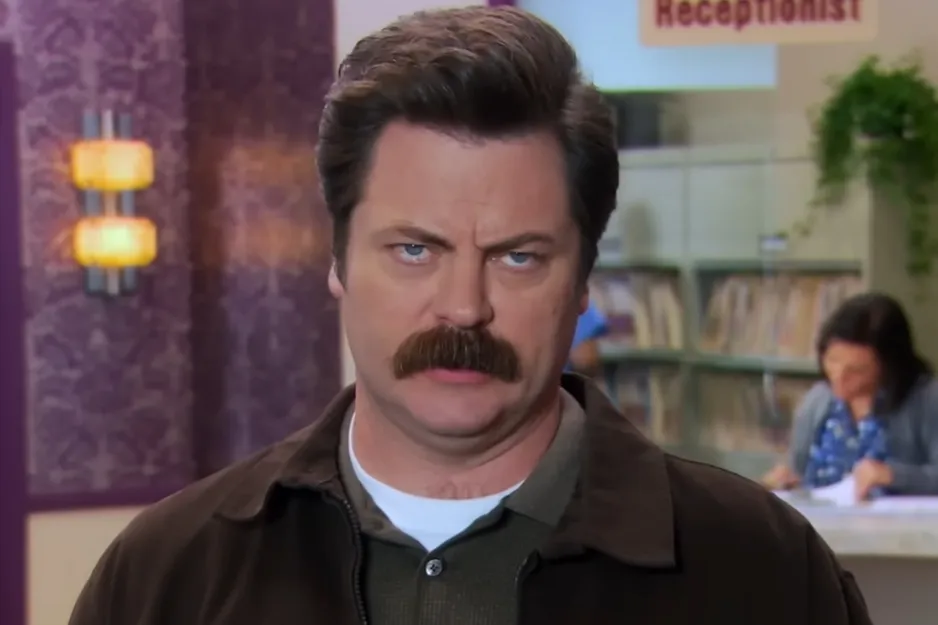 Ron Swanson with mustache in an office setting, representing a popular fictional boss character from Parks and Recreation.
