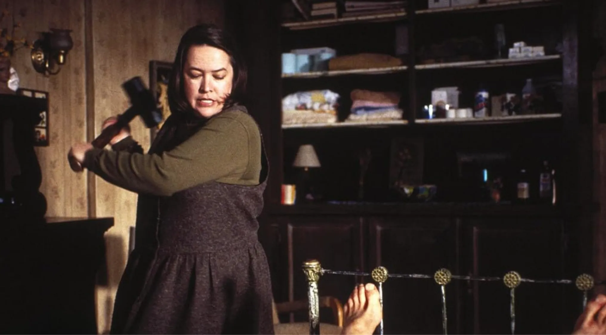 Woman villain from '80s and '90s films wielding a hammer in a tense scene showing obsession turning to cruelty.