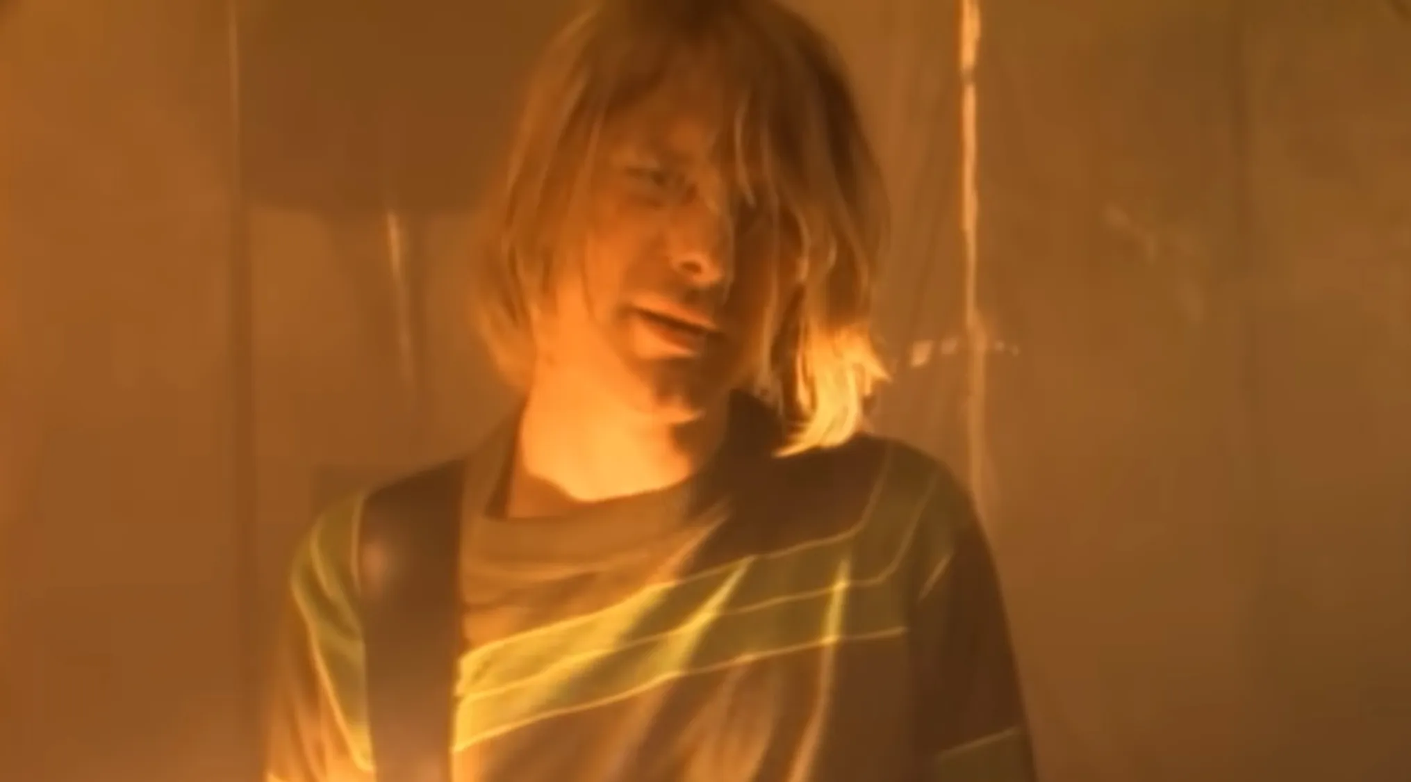 Lead singer performing in warm lighting, part of a music challenge to name bands from their lead singers.