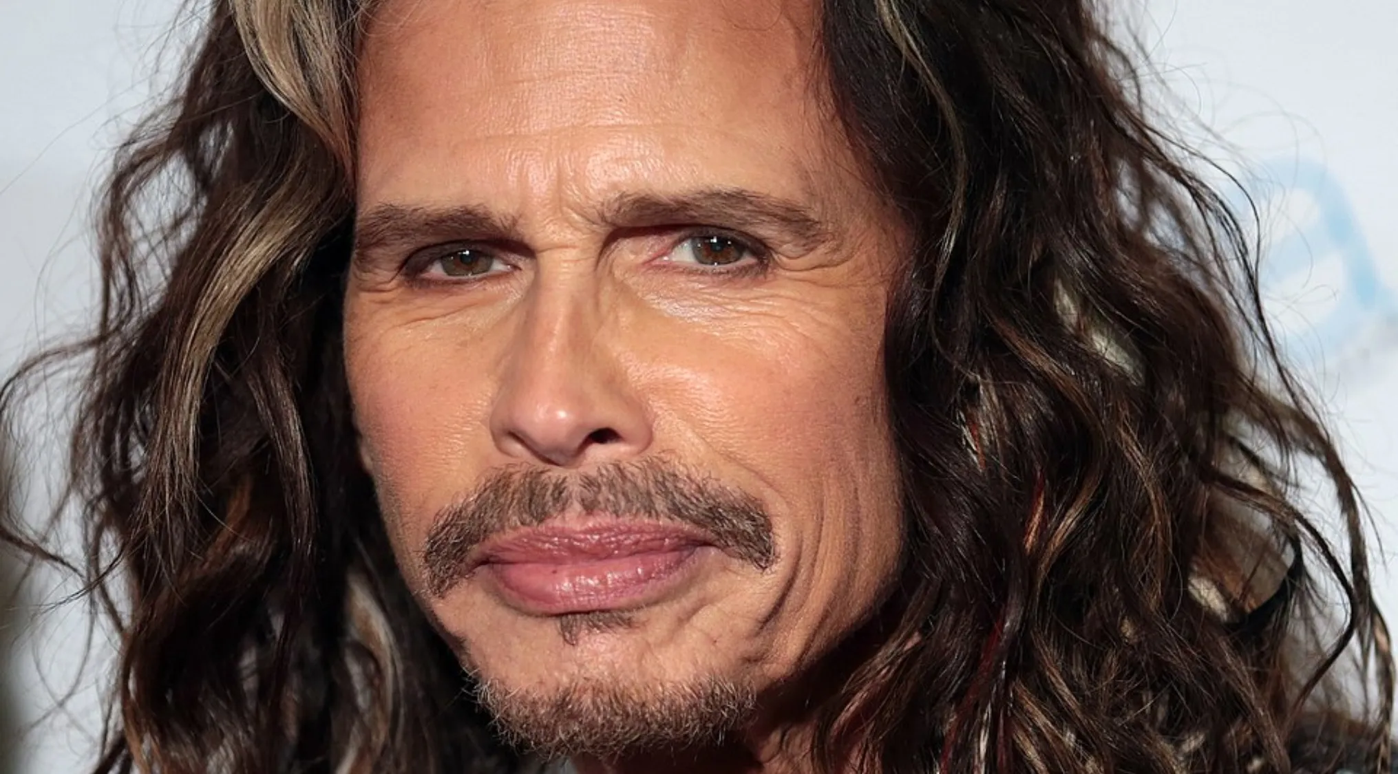Close-up of a man with long hair and a goatee, related to music challenge and lead singers trivia.