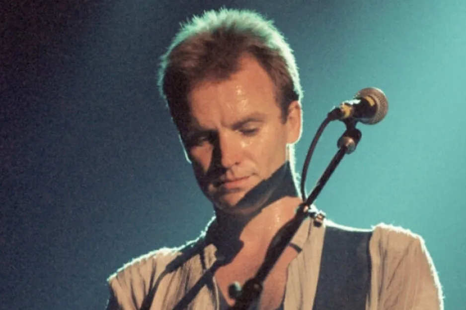 Sting performing on stage as frontman, bassist, and primary songwriter of The Police in a live music setting.