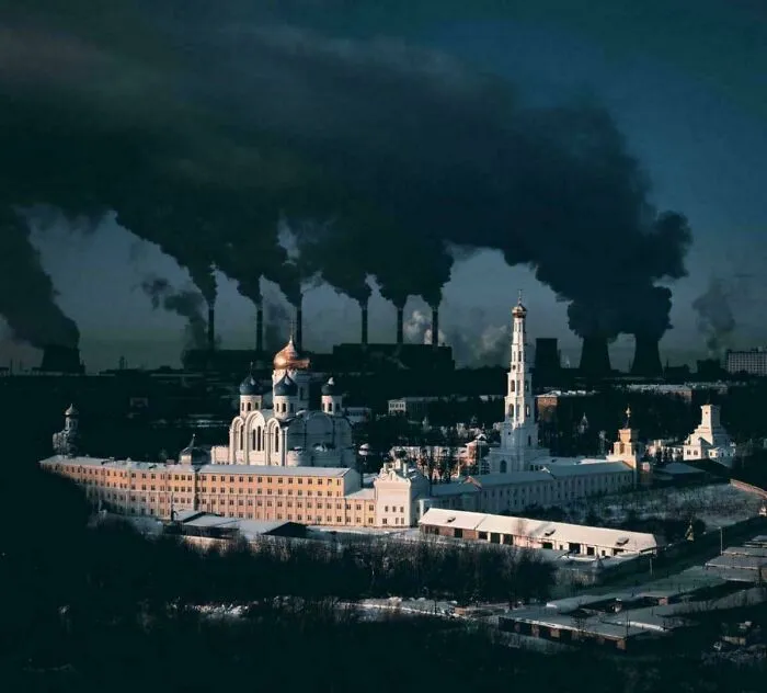 Monasterio Nikolo-Ugreshsky contra las chimeneas humeantes de una planta de CHP, Dzerzhinsky, región de Moscú, Rusia